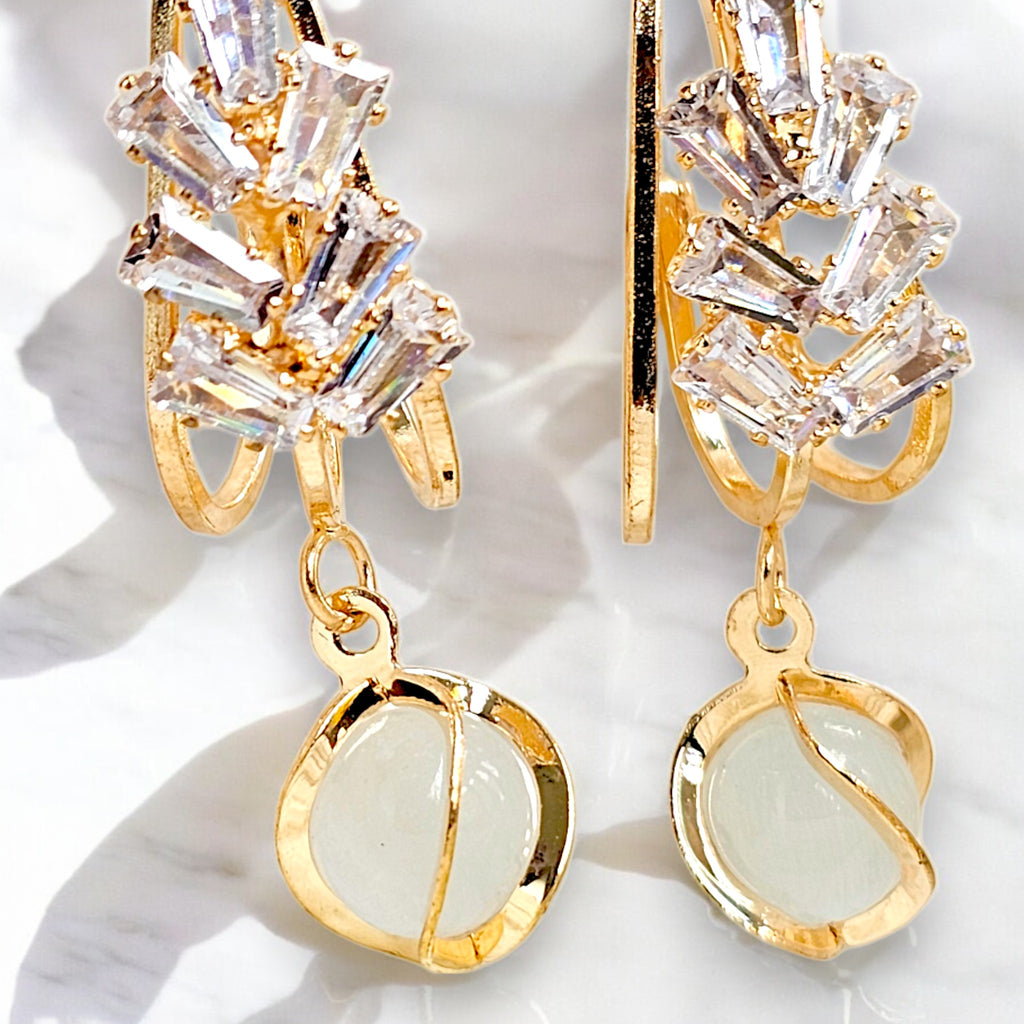 Elegant gold-plated dangle earrings featuring sparkling Zirconia crystals encased in a gold frame