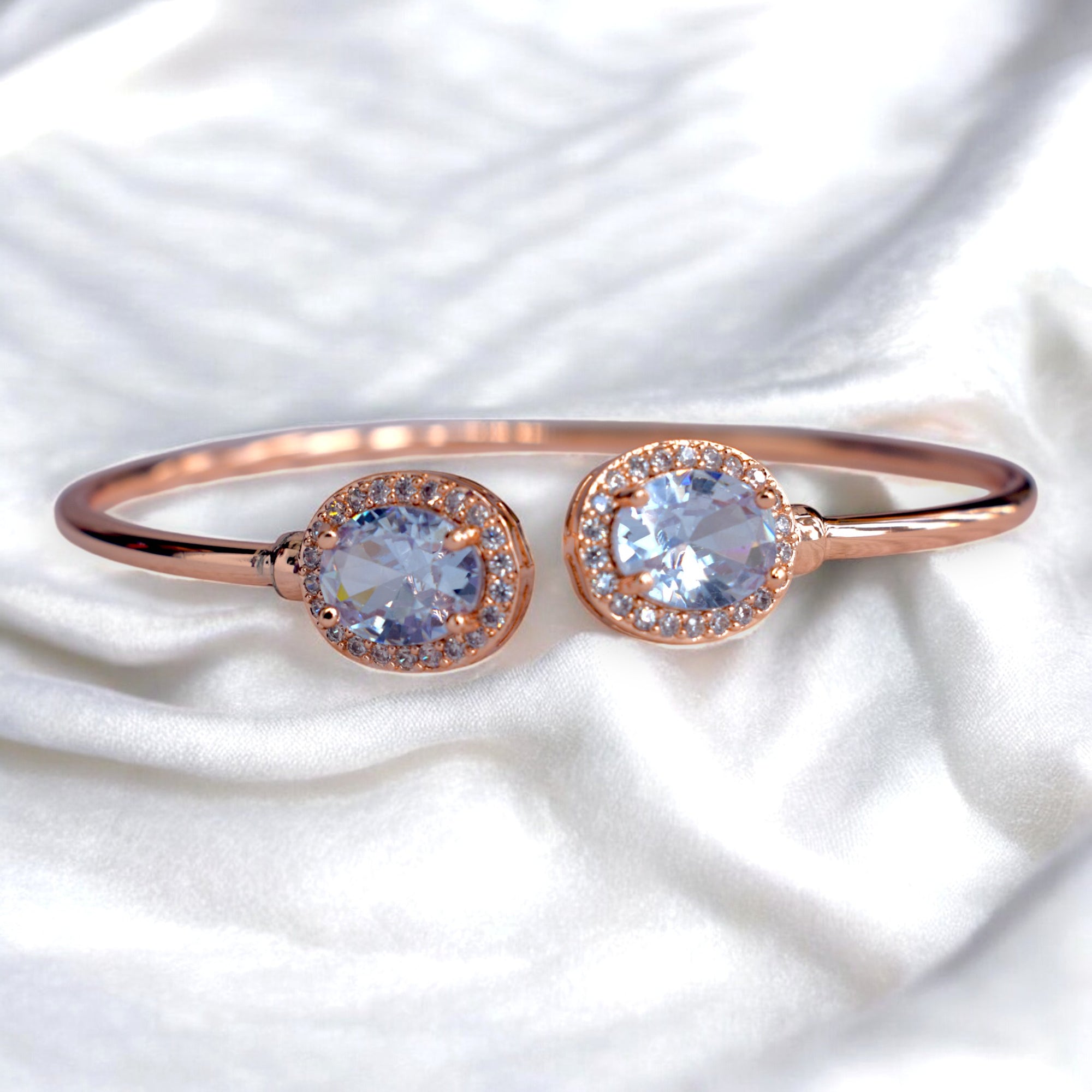 a rose gold two diamond studded bangle placed on a white satin cloth 