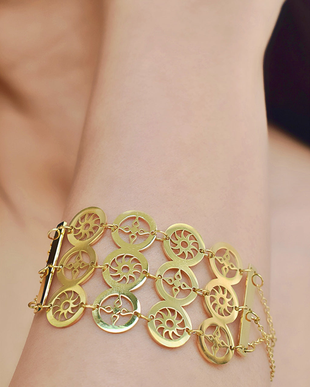 close of a girl wearing a gold color circle design bracelet.