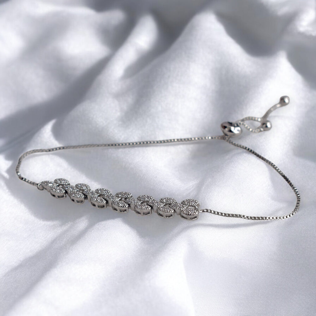silver diamond studded bracelet on a white satin cloth