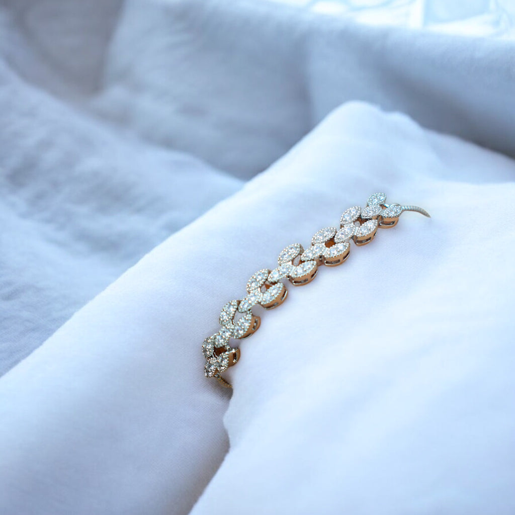 white diamond studded silver bracelet on a white cushion
