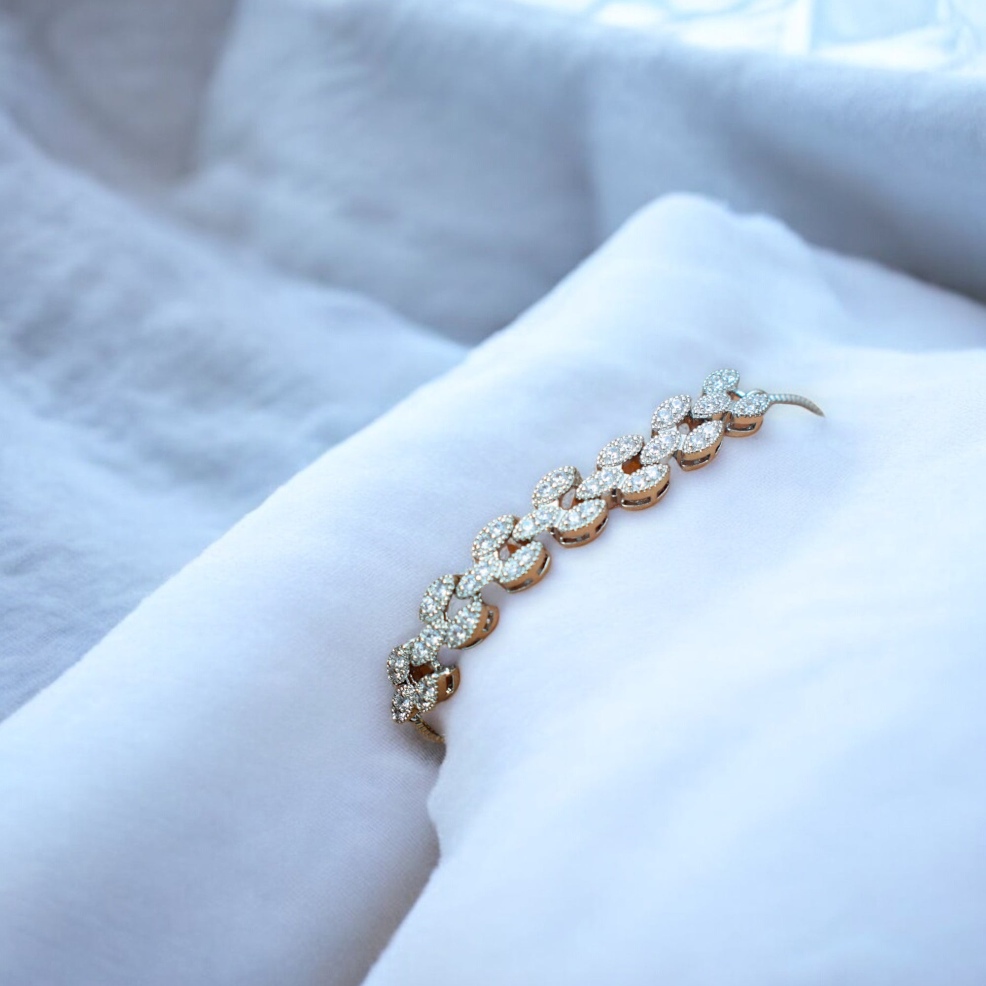 white diamond studded silver bracelet on a white cushion