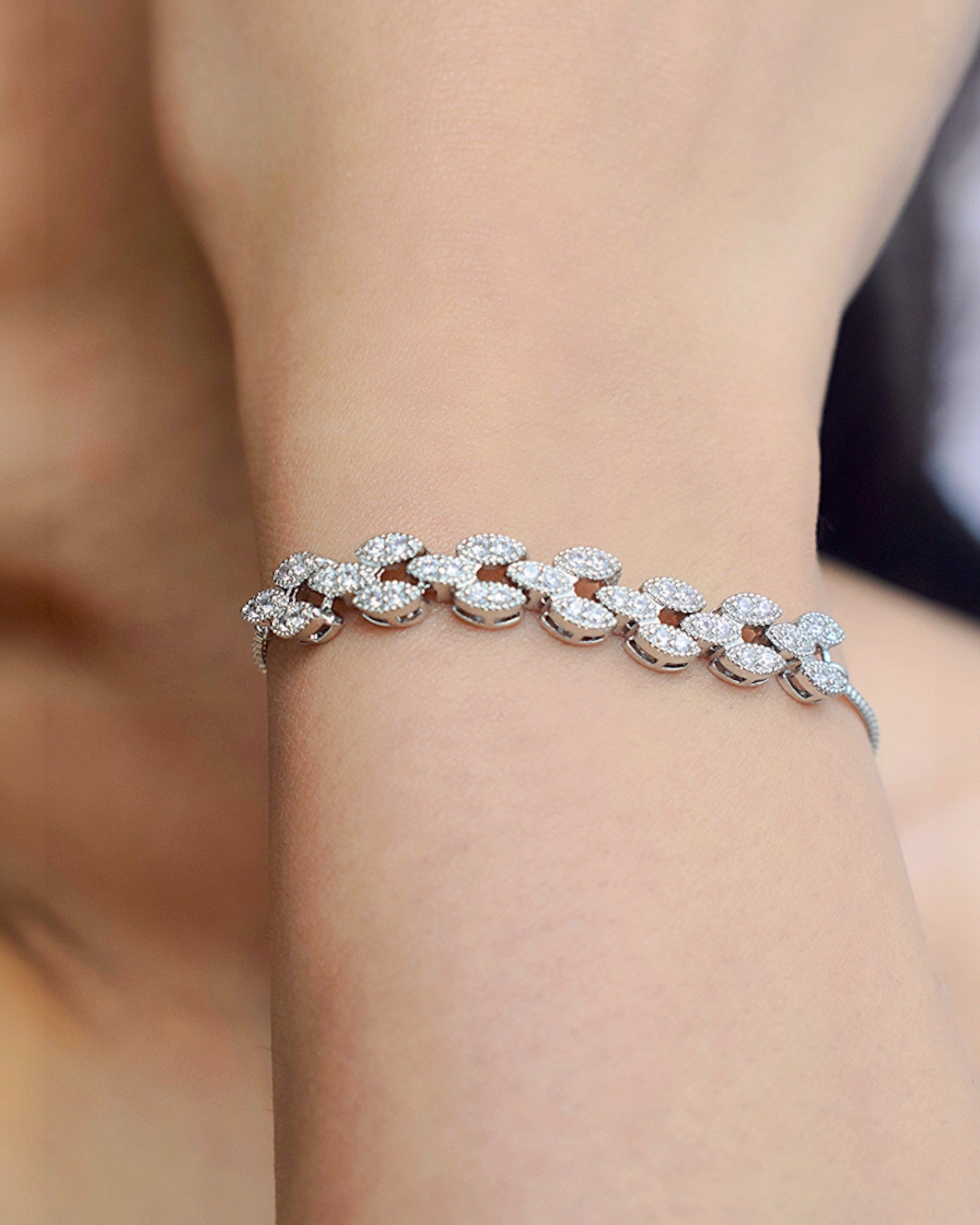 close up of a girl wearing a white diamond studded silver bracelet