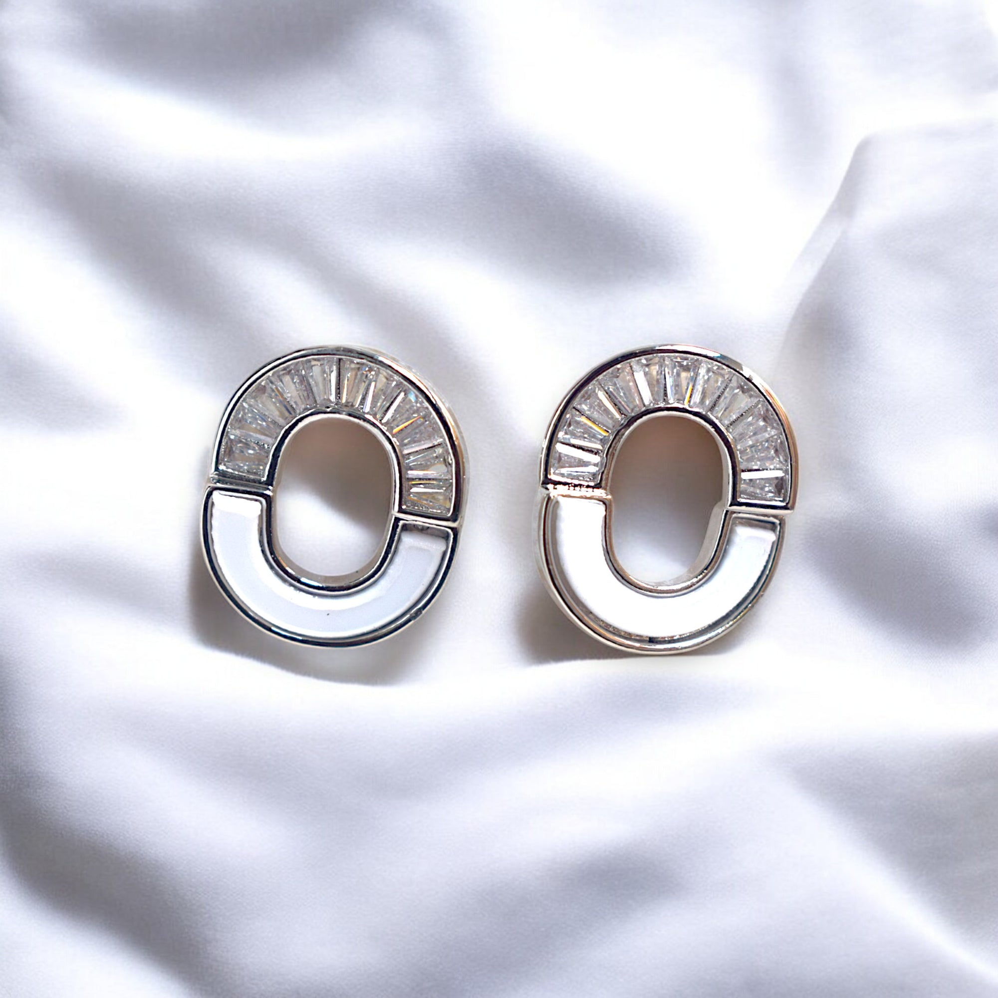 kansobi silver round zirconia stone earrings on a white satin cloth