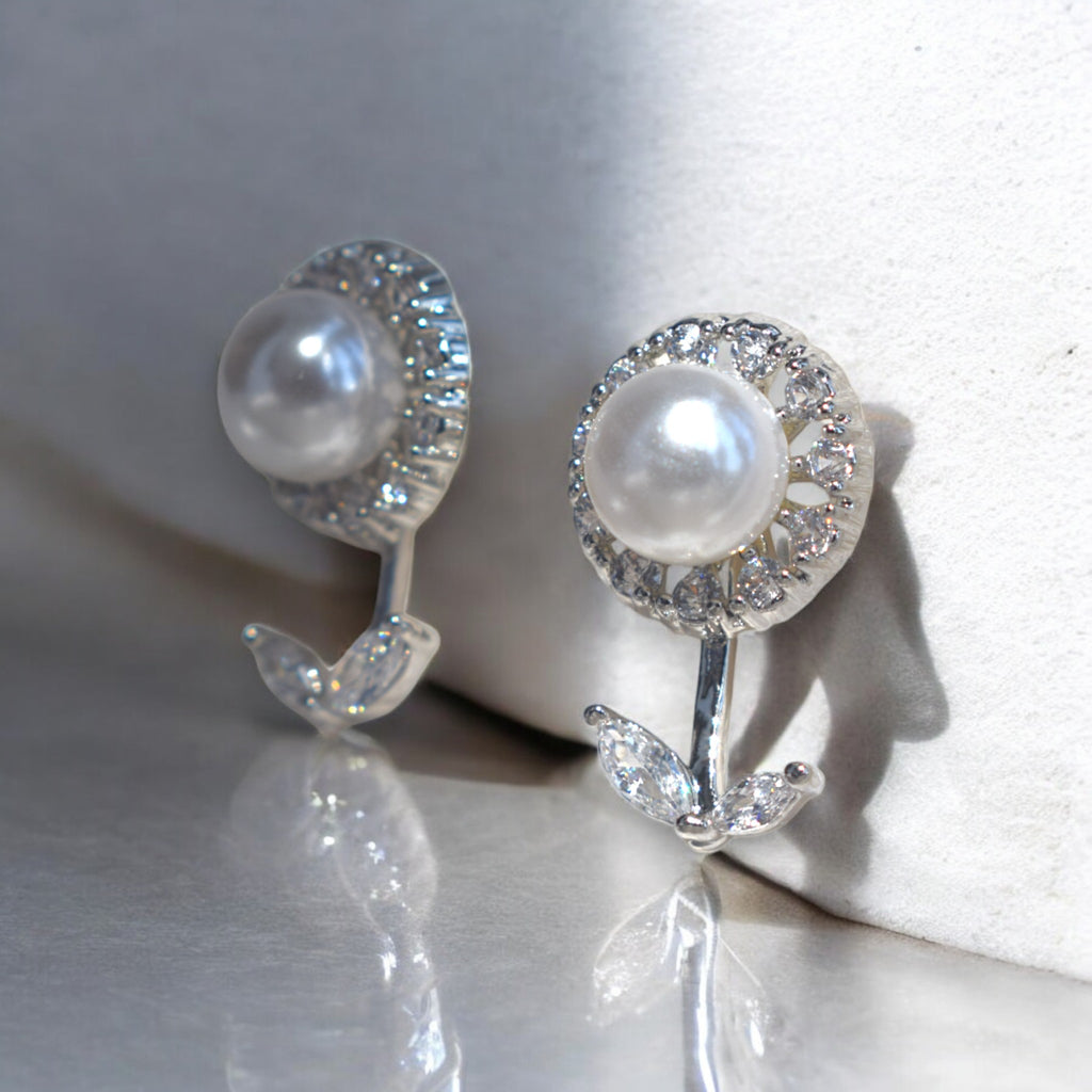 Kansobi Silver Pearl Zirconia Stone earrings kept on a white wall