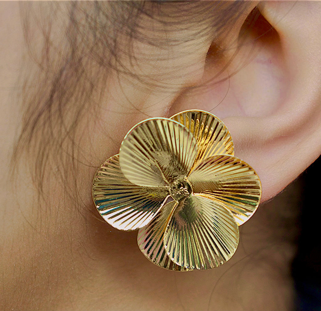 side view of a 14k Gold flower petal earring worn by a girl