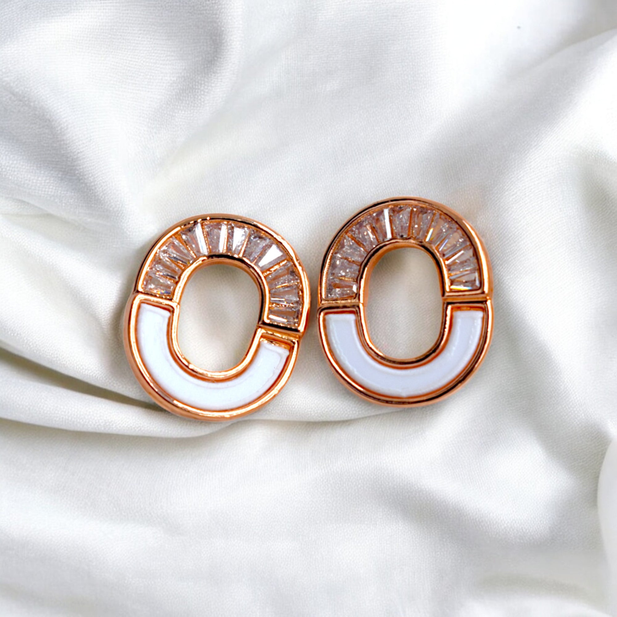 kansobi rose gold round zirconia stone earrings on a white satin cloth