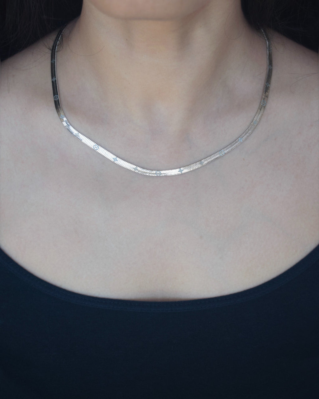 Silver necklace on a person wearing a black top