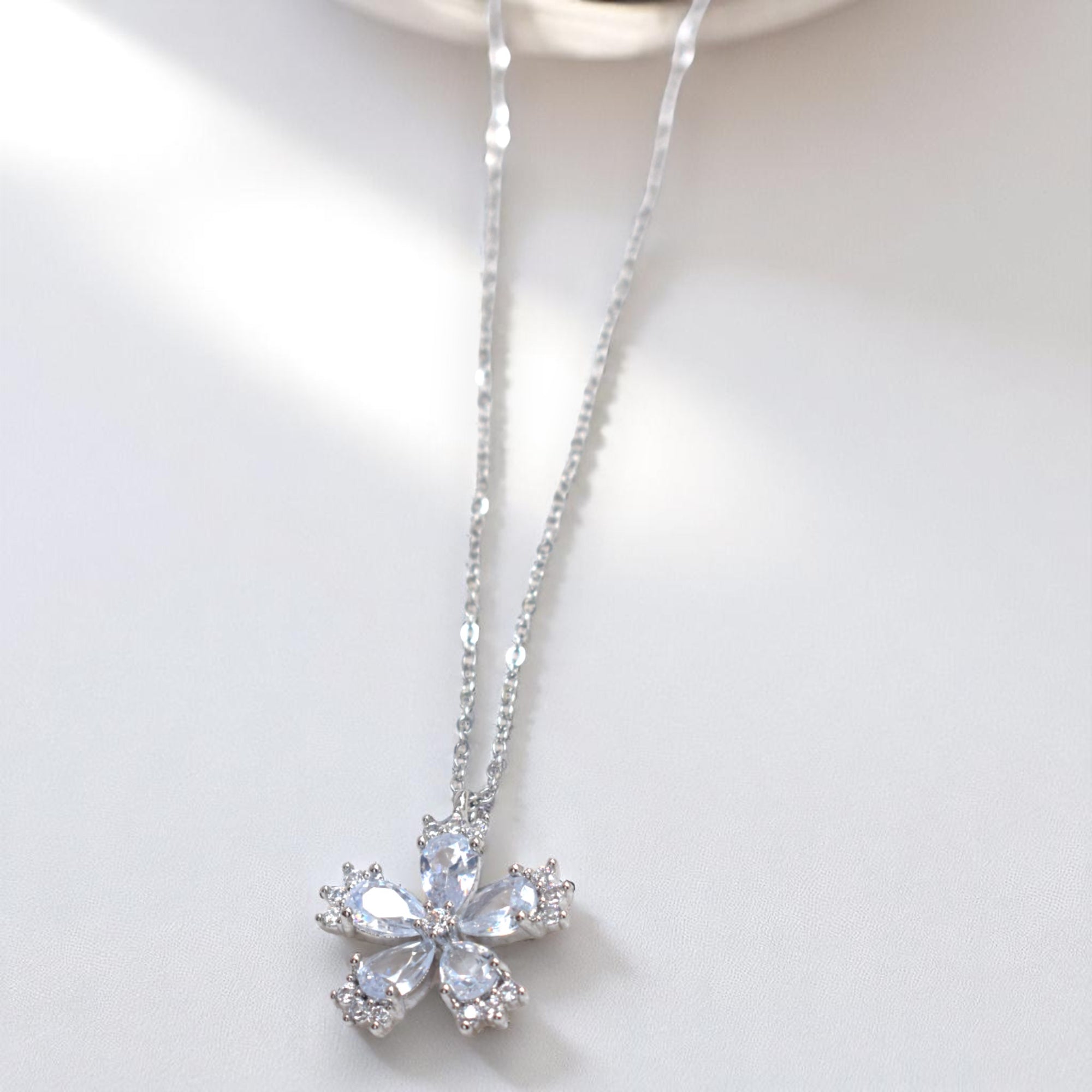 Silver necklace with a snowflake pendant on a white background