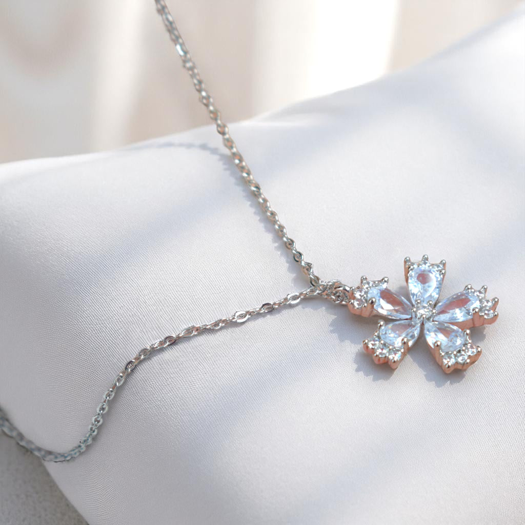 Silver necklace with a butterfly-shaped pendant on a white surface