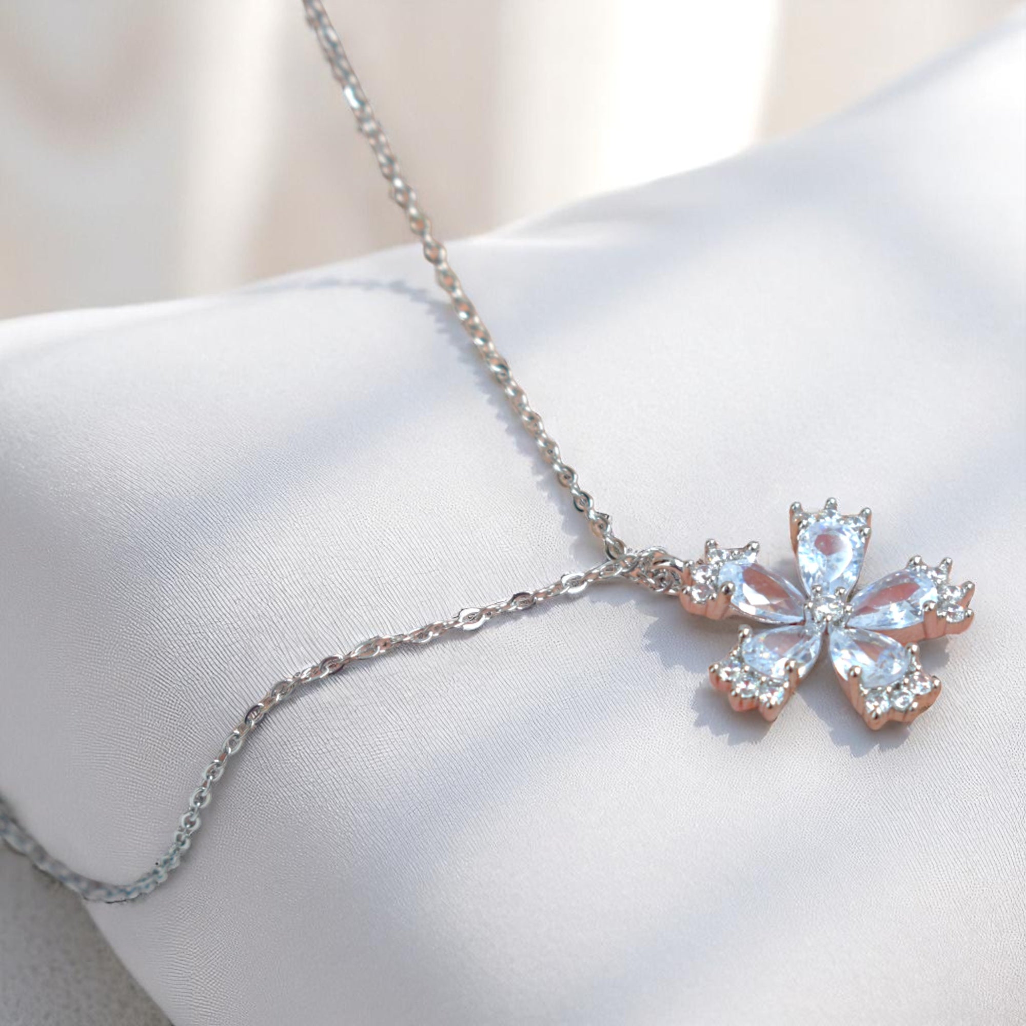 Silver necklace with a butterfly-shaped pendant on a white surface