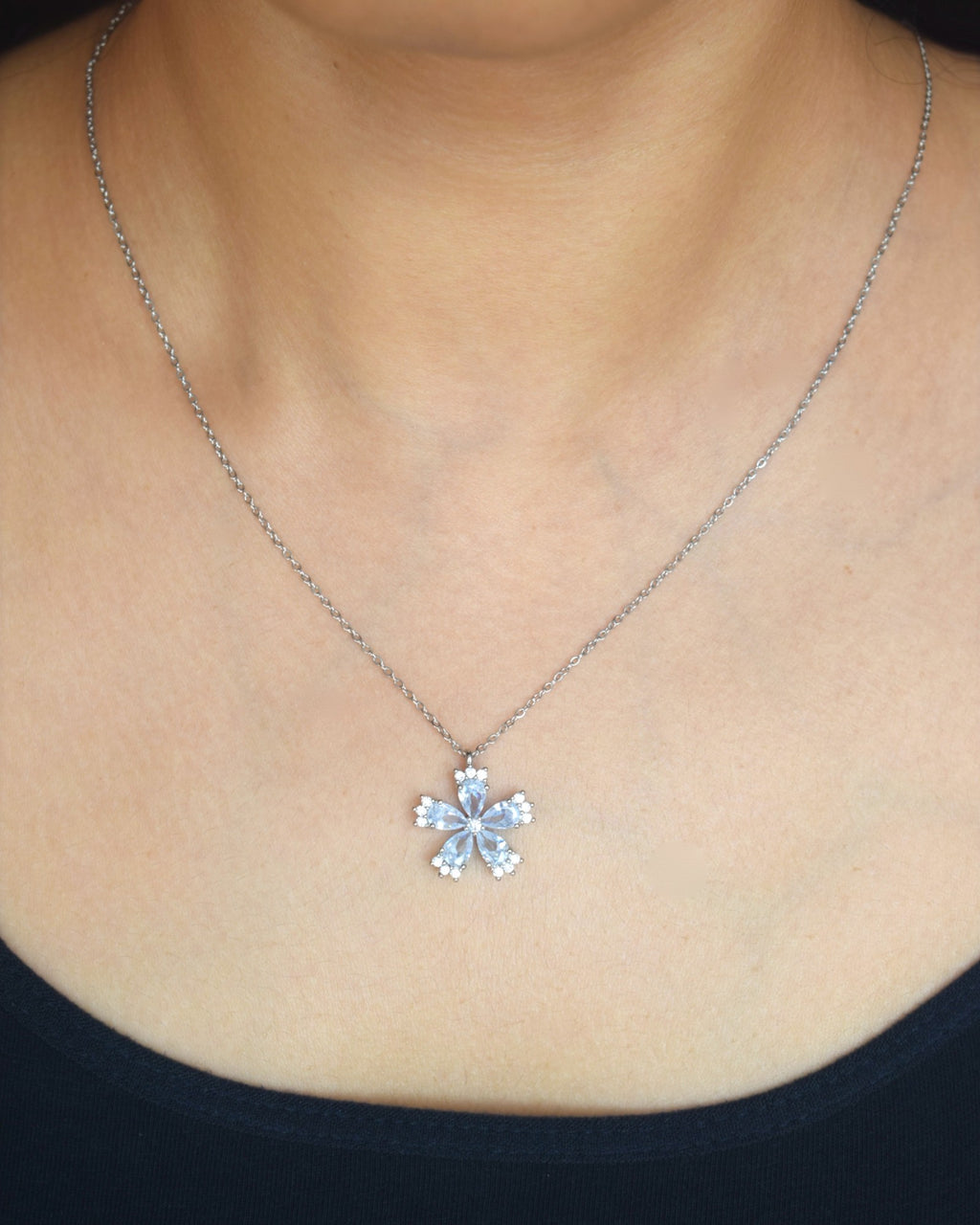 Snowflake pendant necklace on a person wearing a black top