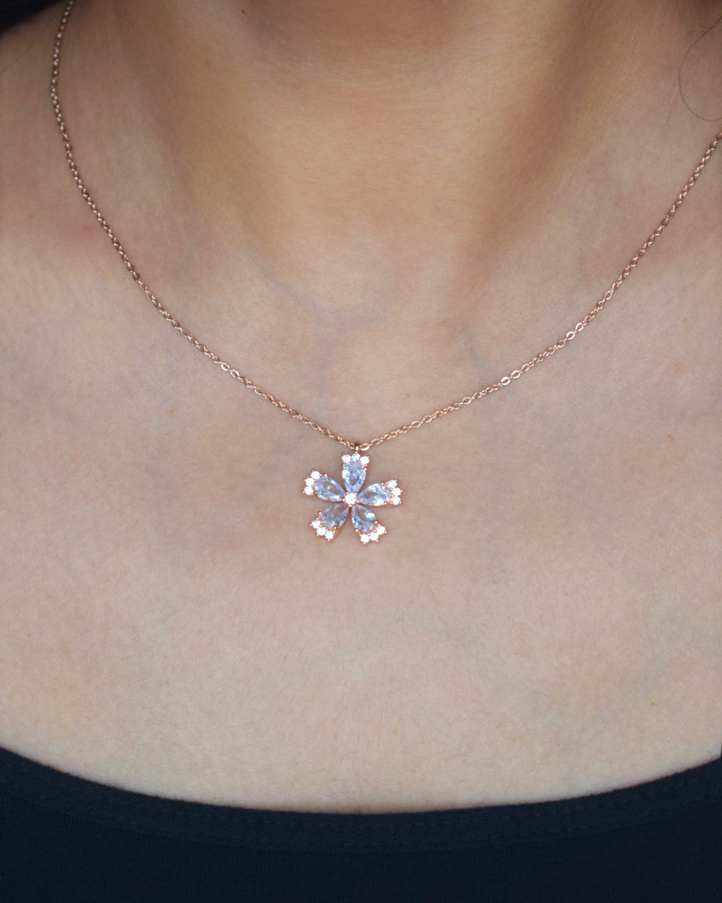 Necklace with a floral pendant on a person's neck