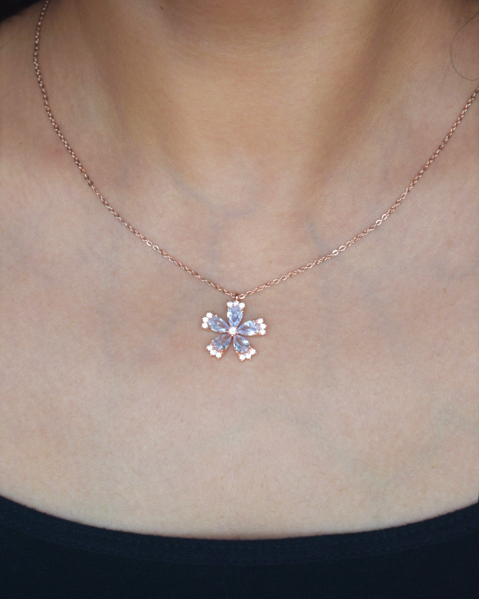 Necklace with a floral pendant on a person's neck