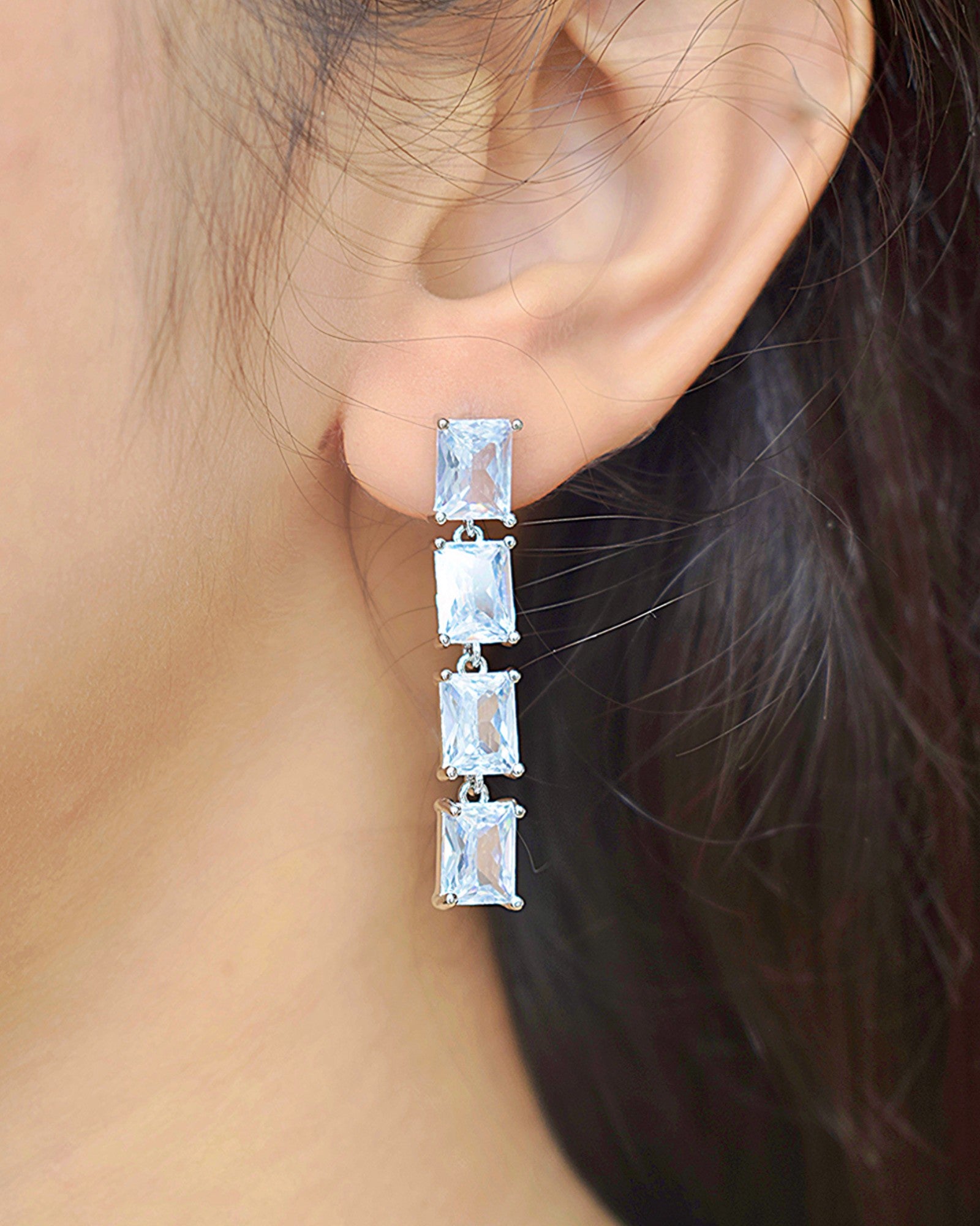 a girl wearing a silver zirconia stoned drop earring
