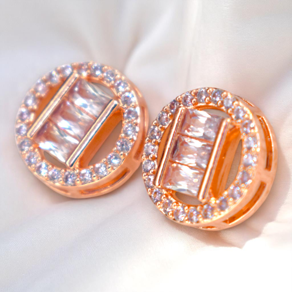 Rose gold earrings with clear gemstones on a white background