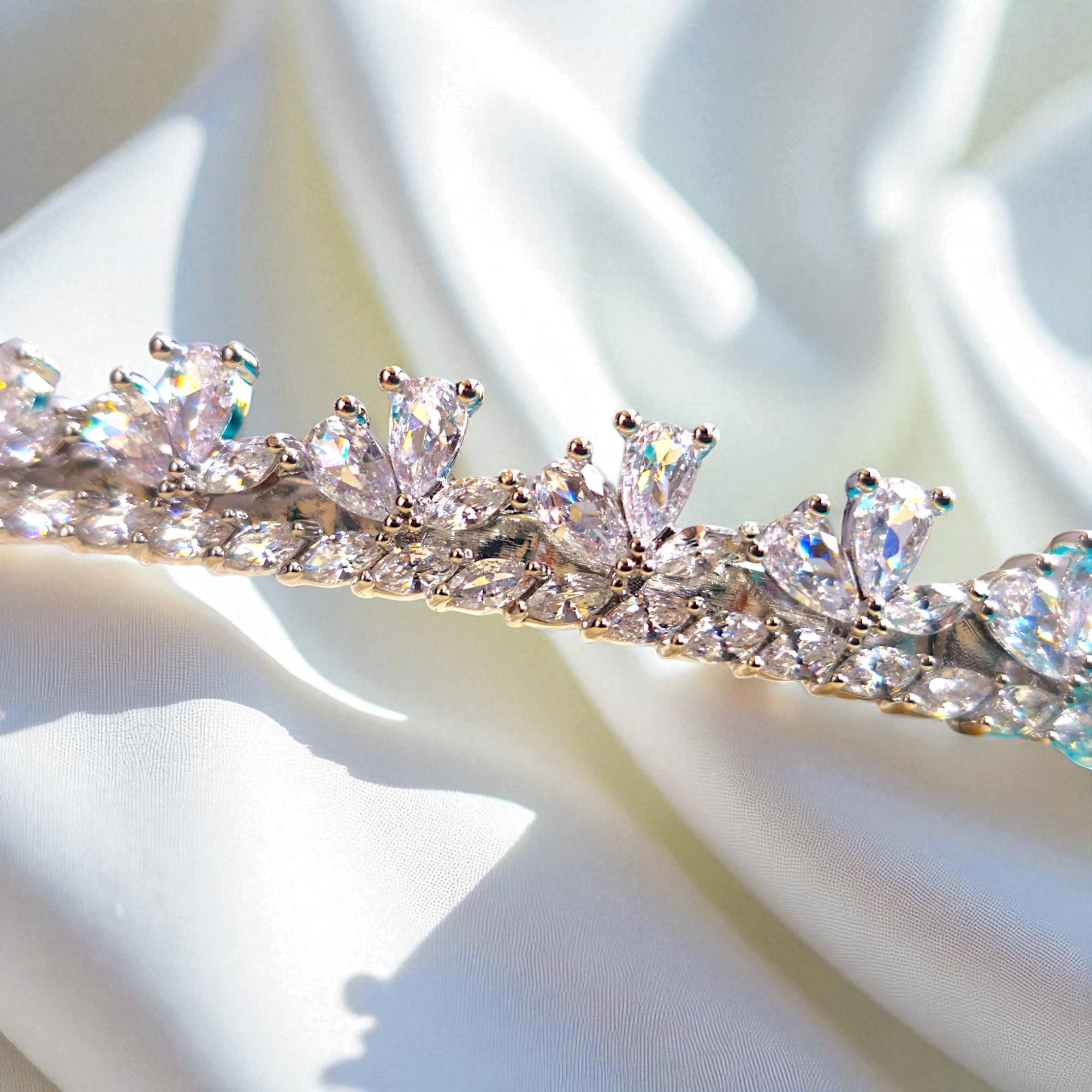 Close-up of a sparkling diamond tiara on a soft white fabric background