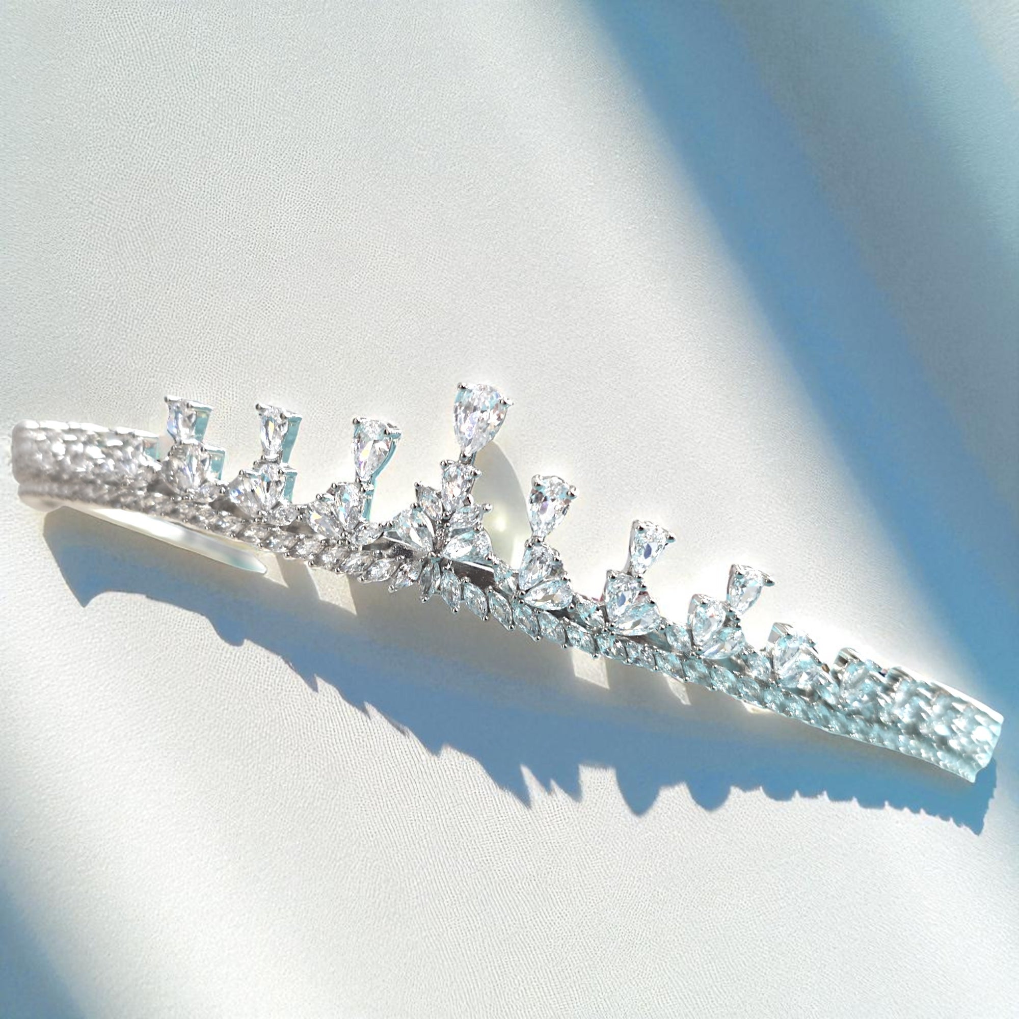 Silver tiara with clear gemstones on a light background