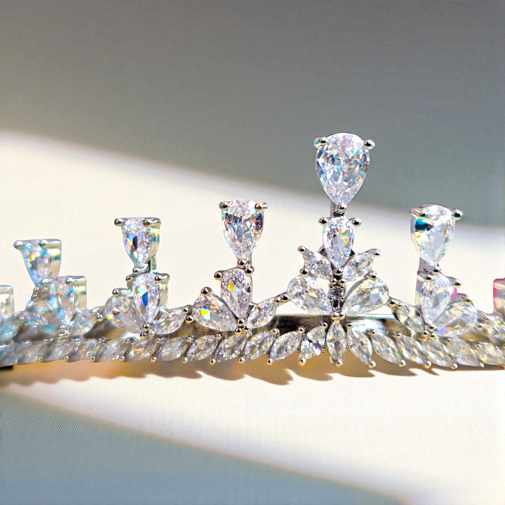 Diamanté tiara on a reflective surface with a neutral background