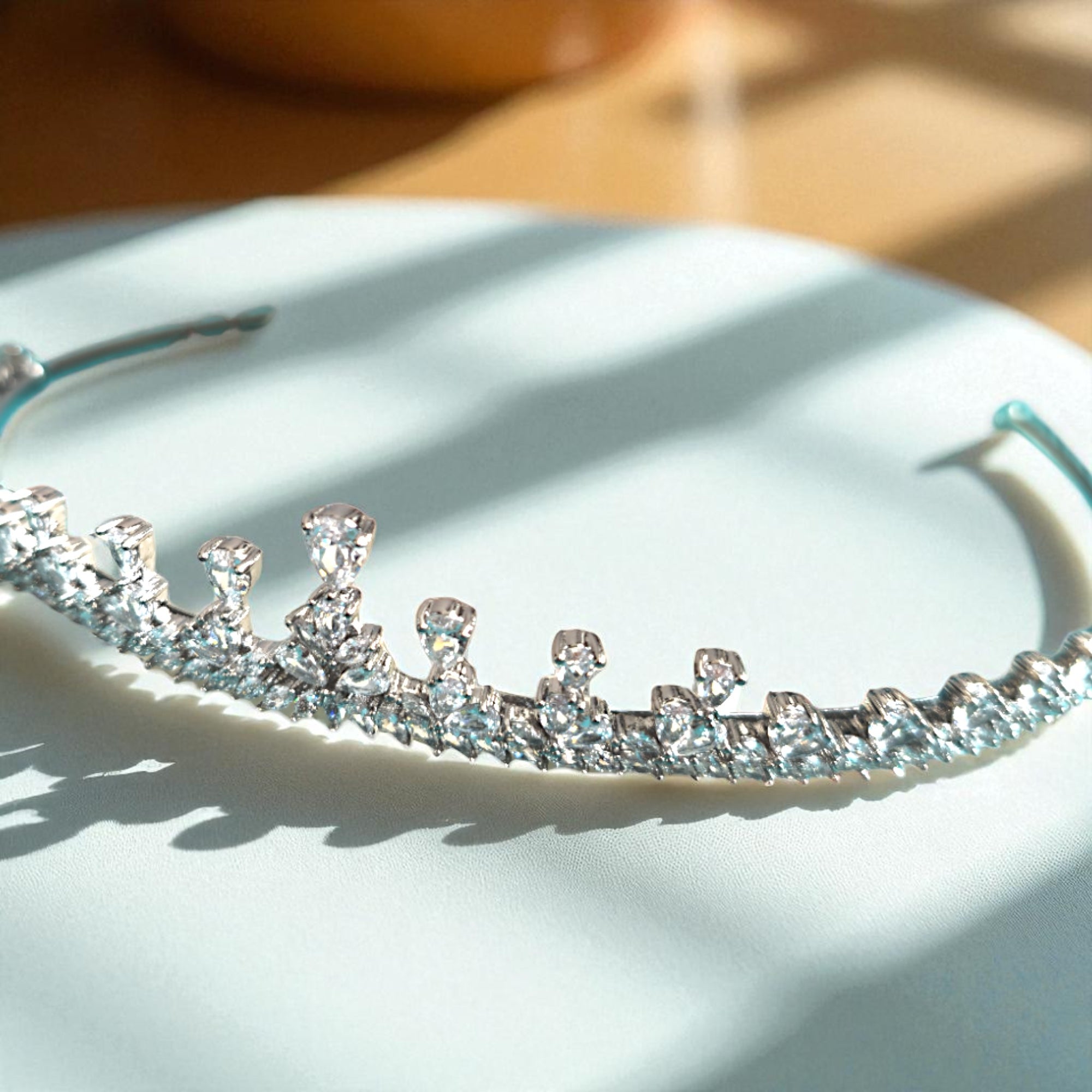 Silver tiara with clear stones on a light surface