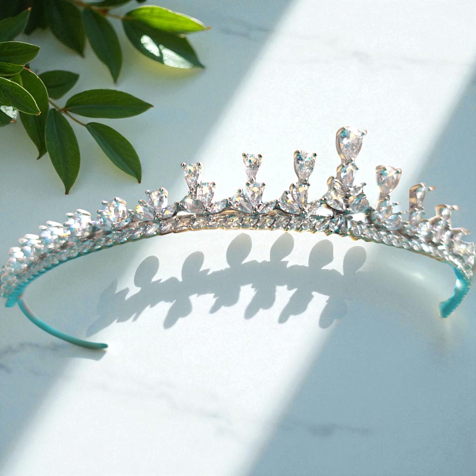 Silver tiara with clear crystals on a light background