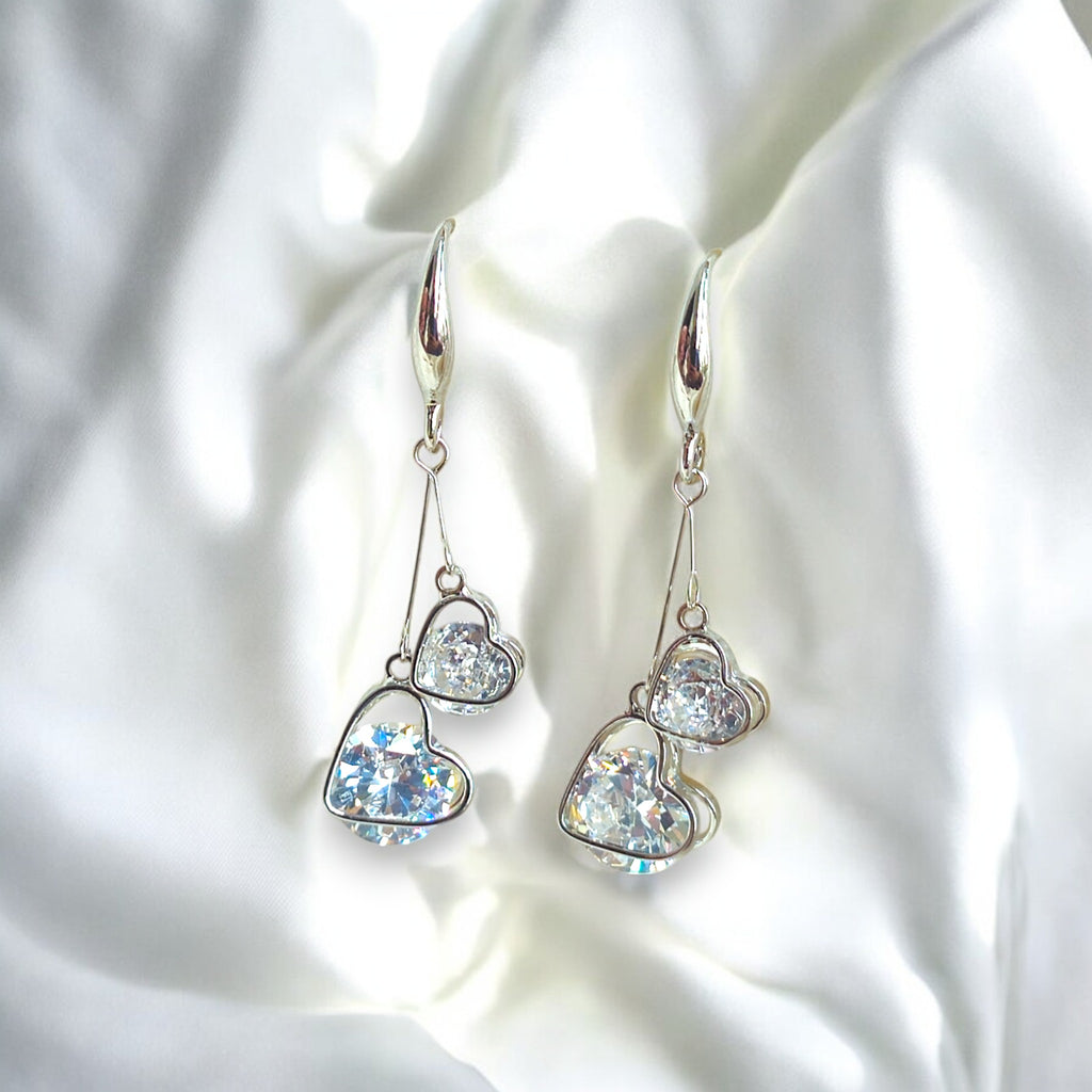 Silver heart-shaped dangle earrings with sparkling cubic zirconia crystals