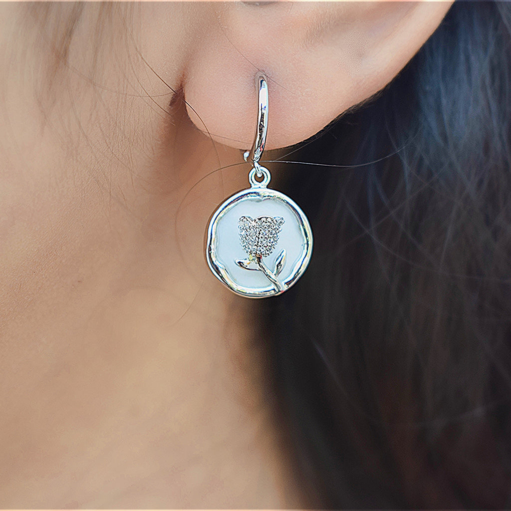 Girl wearing a silver round flower earrings with Zirconia stones