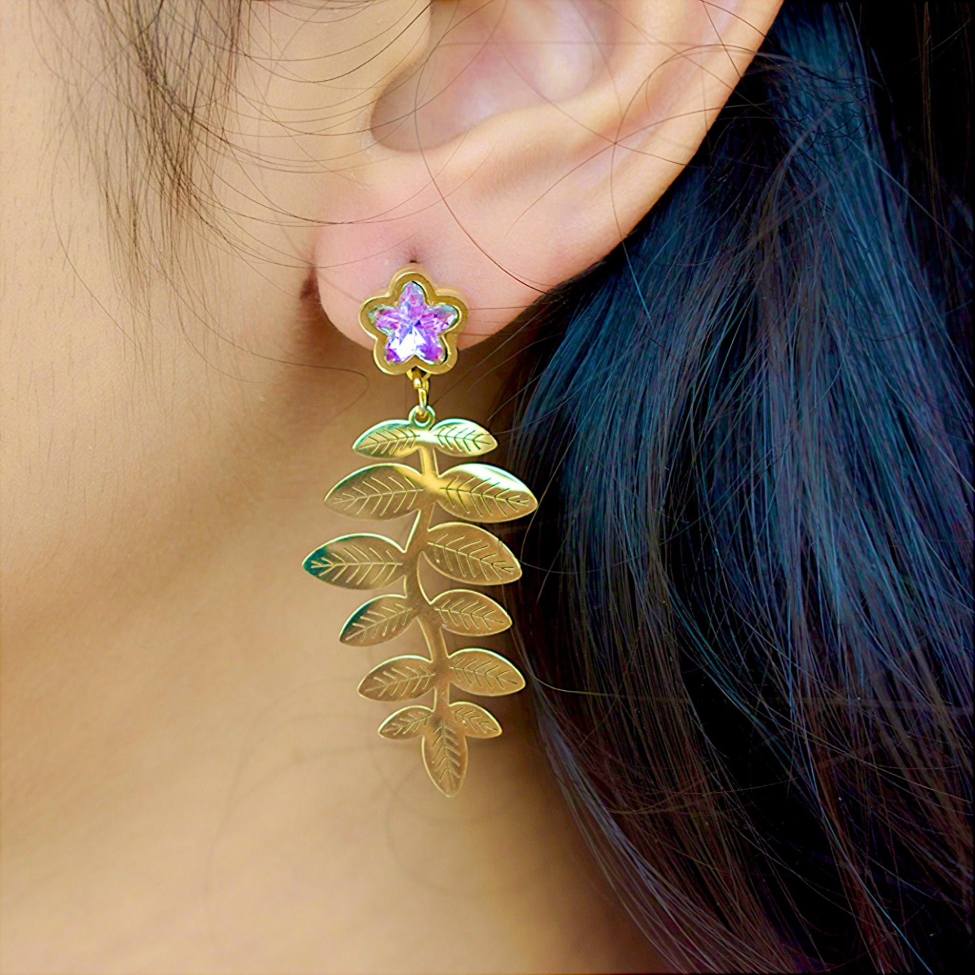 side view of a 14k golden fern leaf earring with zirconia star diamond