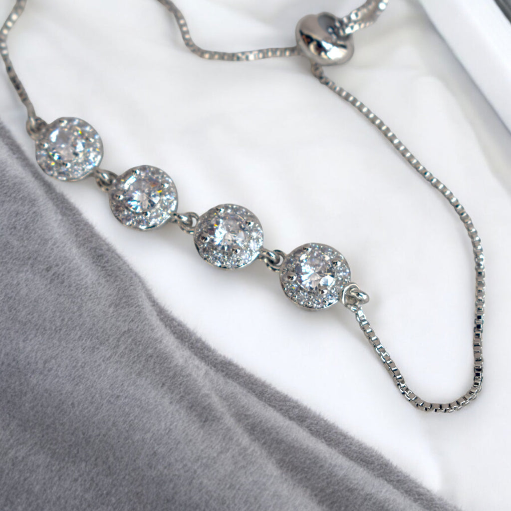 close up of a diamond stoned silver circle chain bracelet on a white marble floor