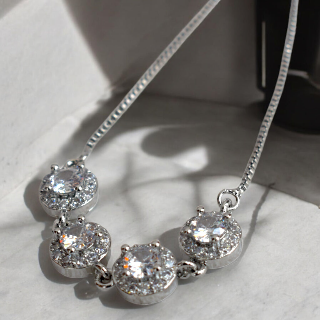 close up of a diamond stoned silver circle chain bracelet on a white cushion floor