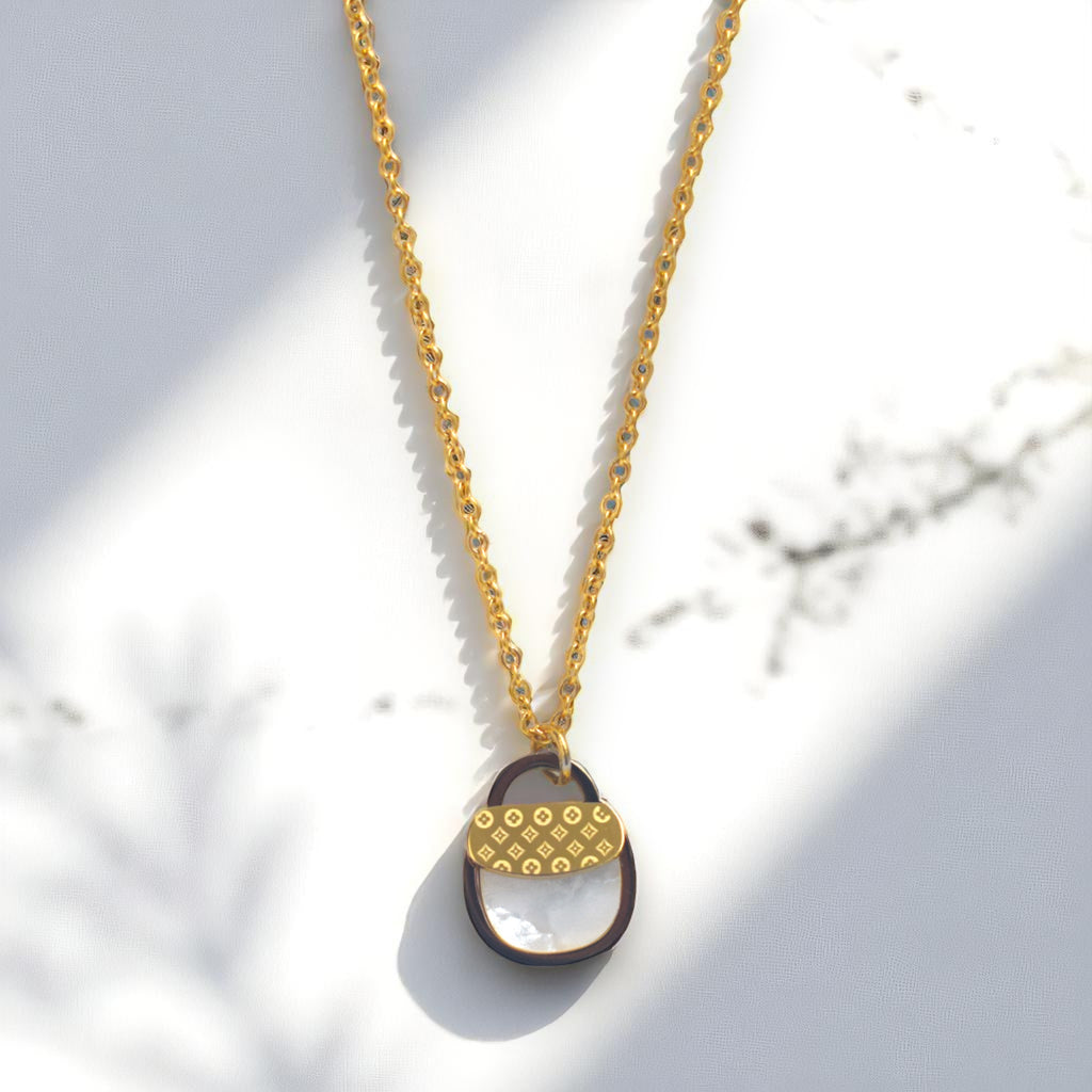 Necklace with a gold chain and unique pendant on a light background