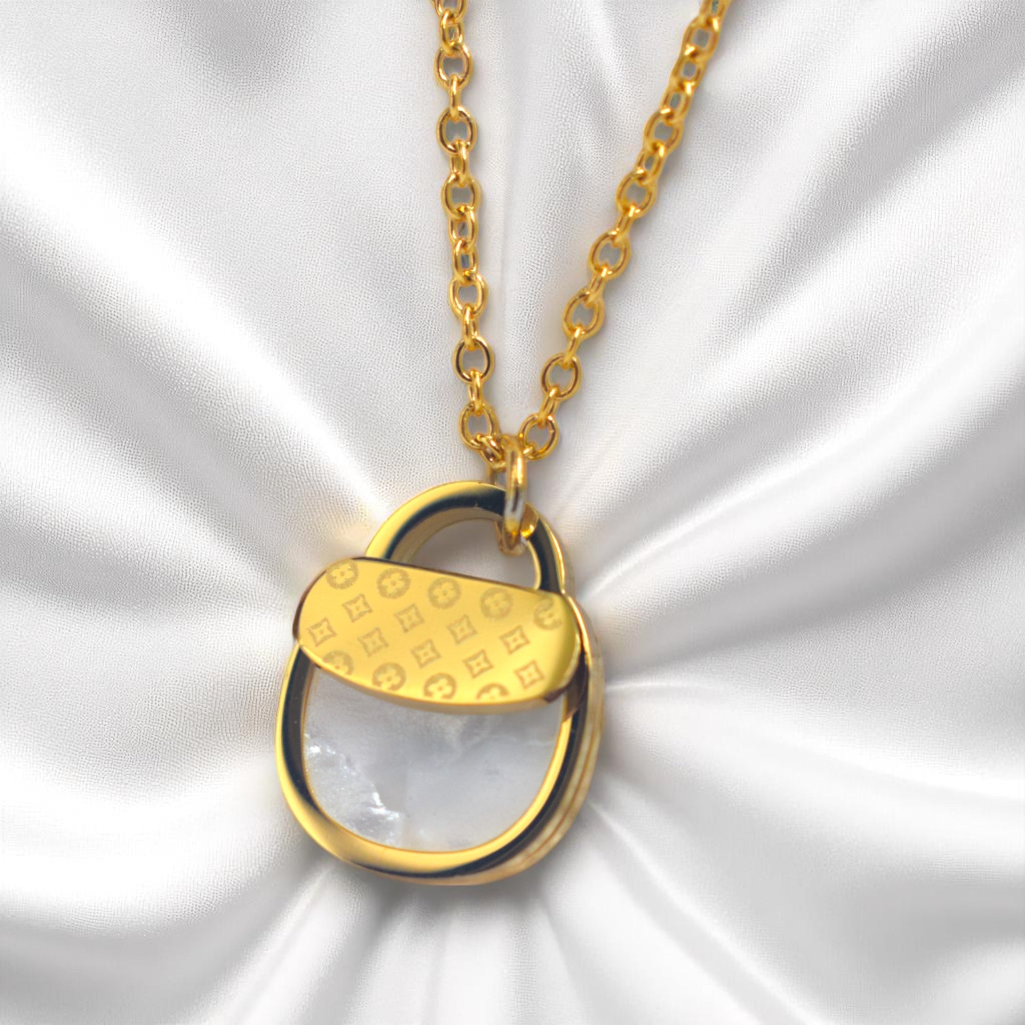 Gold necklace with a unique pendant on a white fabric background