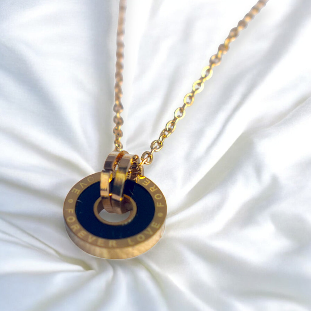 Gold necklace with a blue pendant on a white fabric background