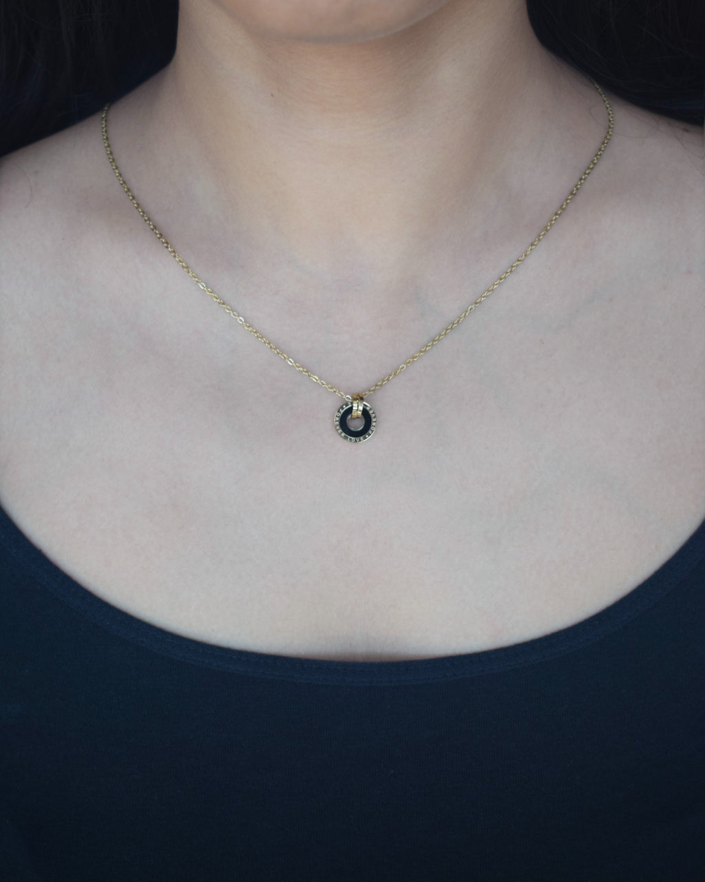 Necklace with a pendant worn by a person against a dark background