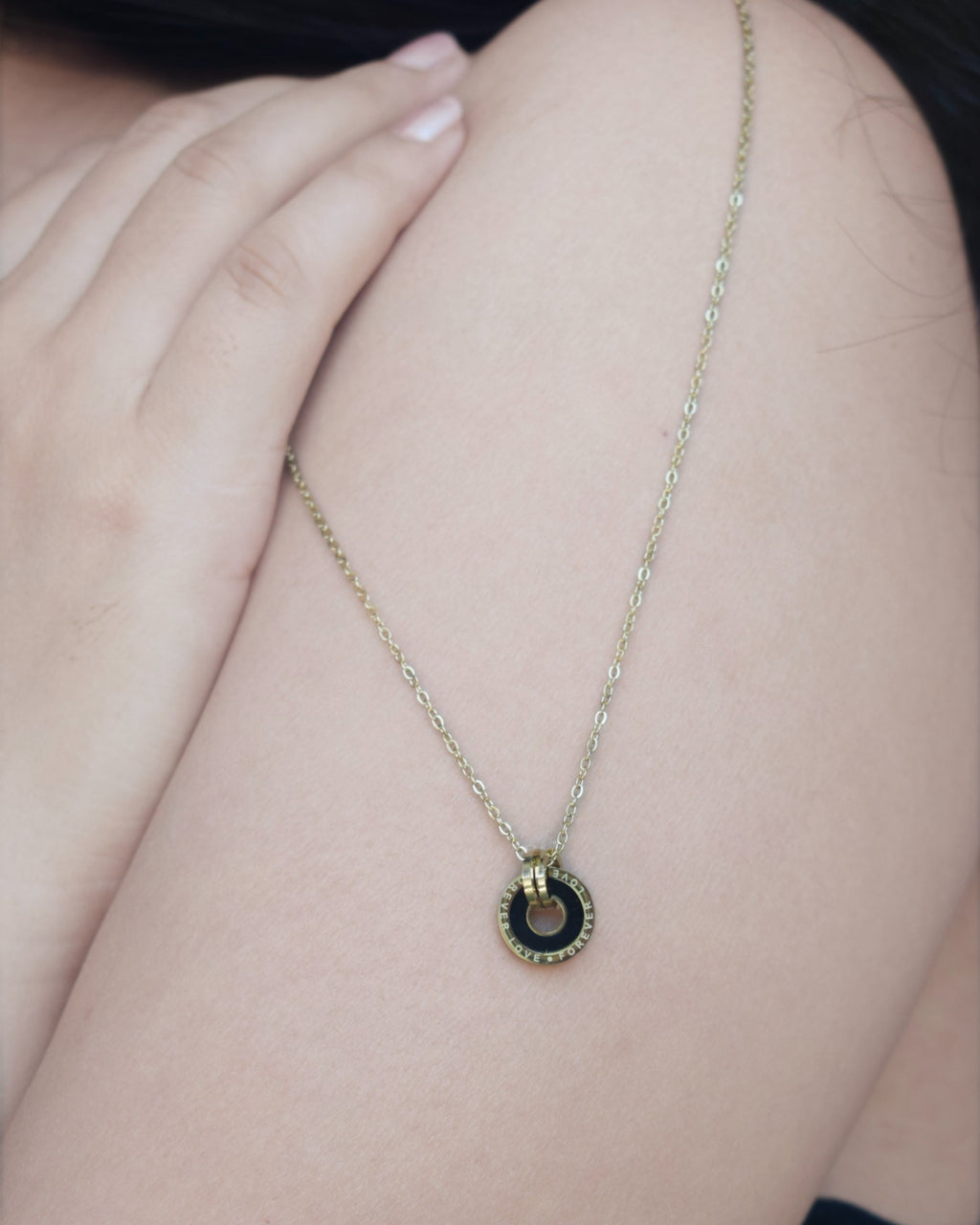 Necklace with a circular pendant on a person's shoulder