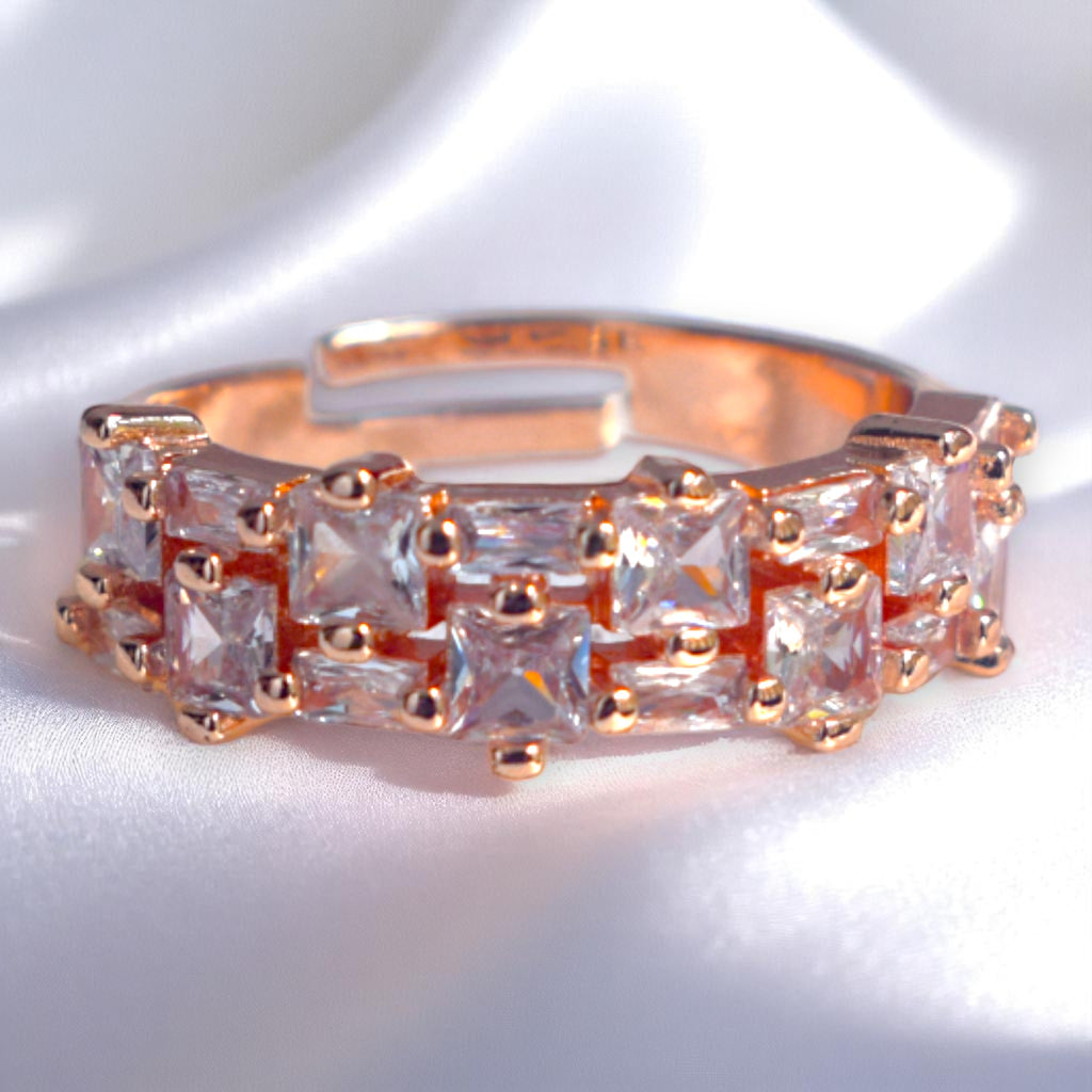 Rose gold ring with zirconia gemstones on a white satin background