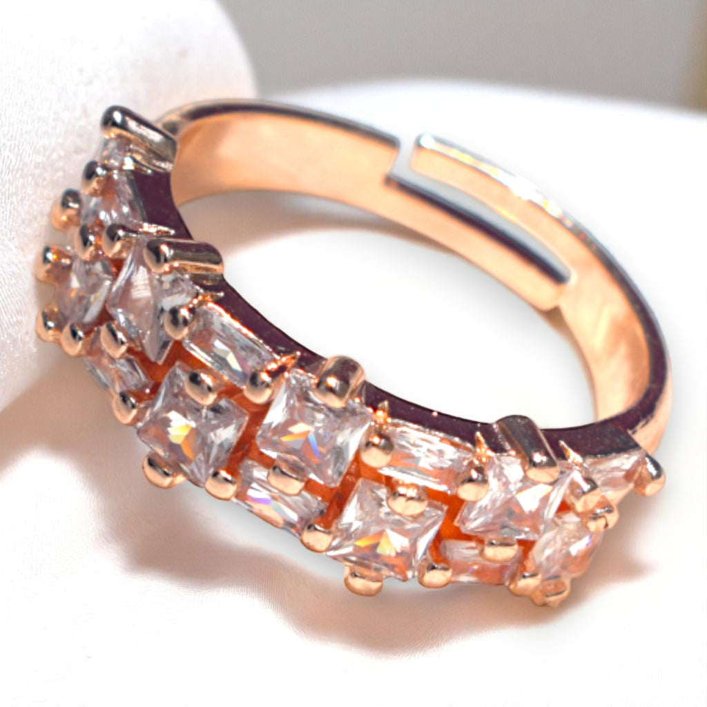 Rose gold ring with zirconia gemstones on a white satin background