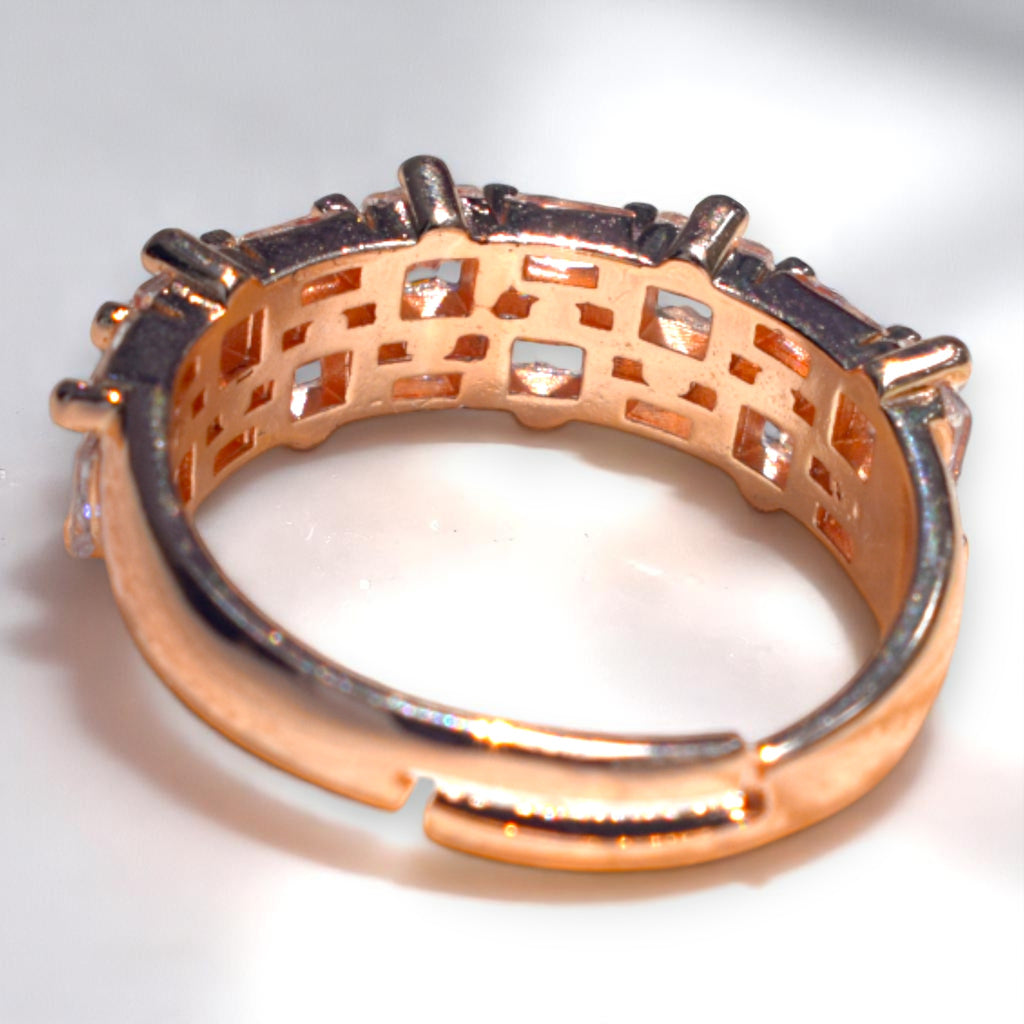 Rose gold ring with intricate design on a white background