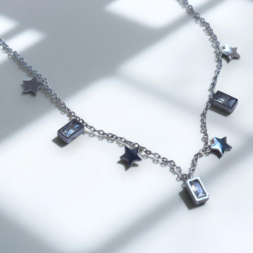 Necklace with star and rectangular charm pendants on a light background
