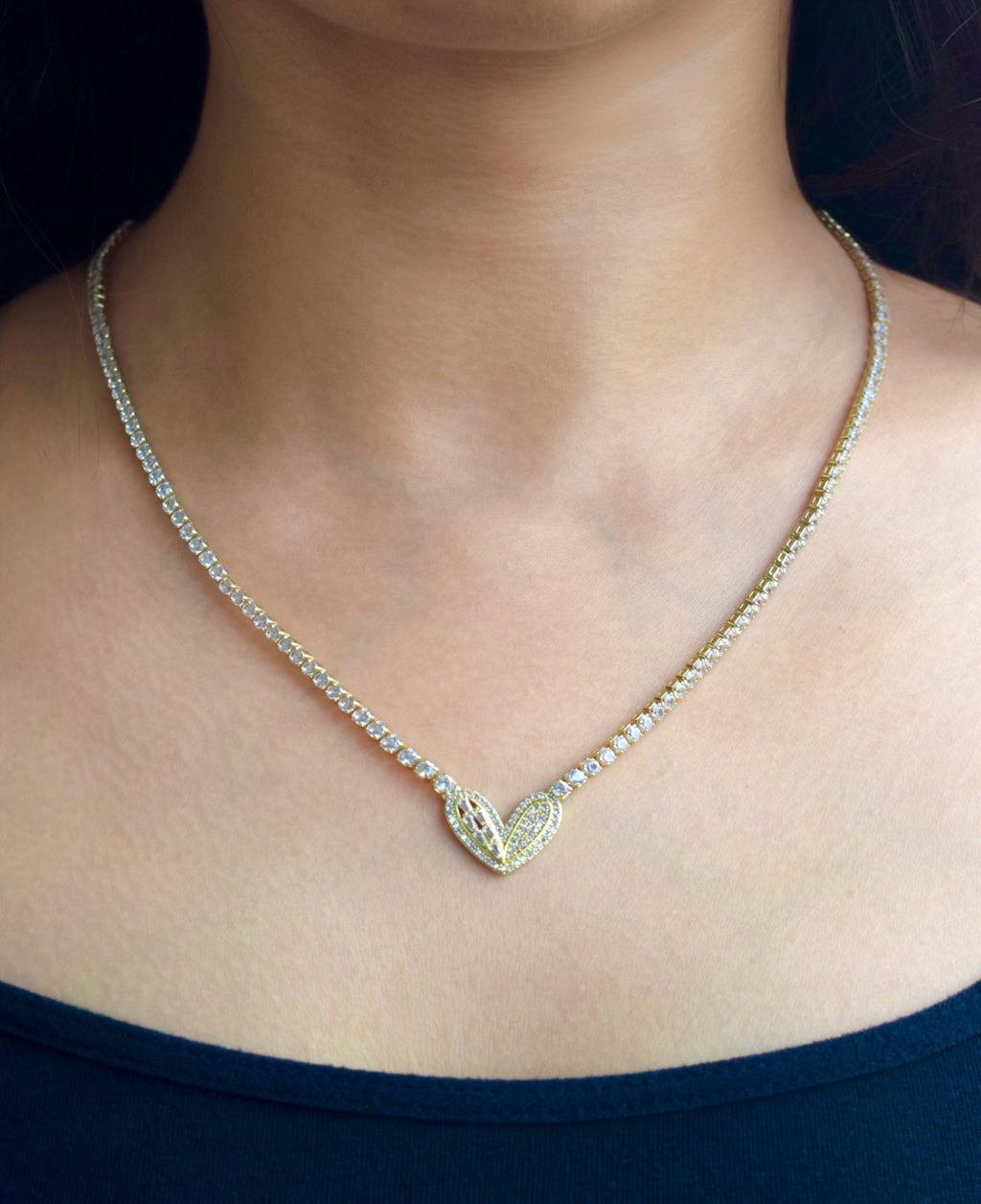 Necklace with a heart-shaped pendant worn by a person