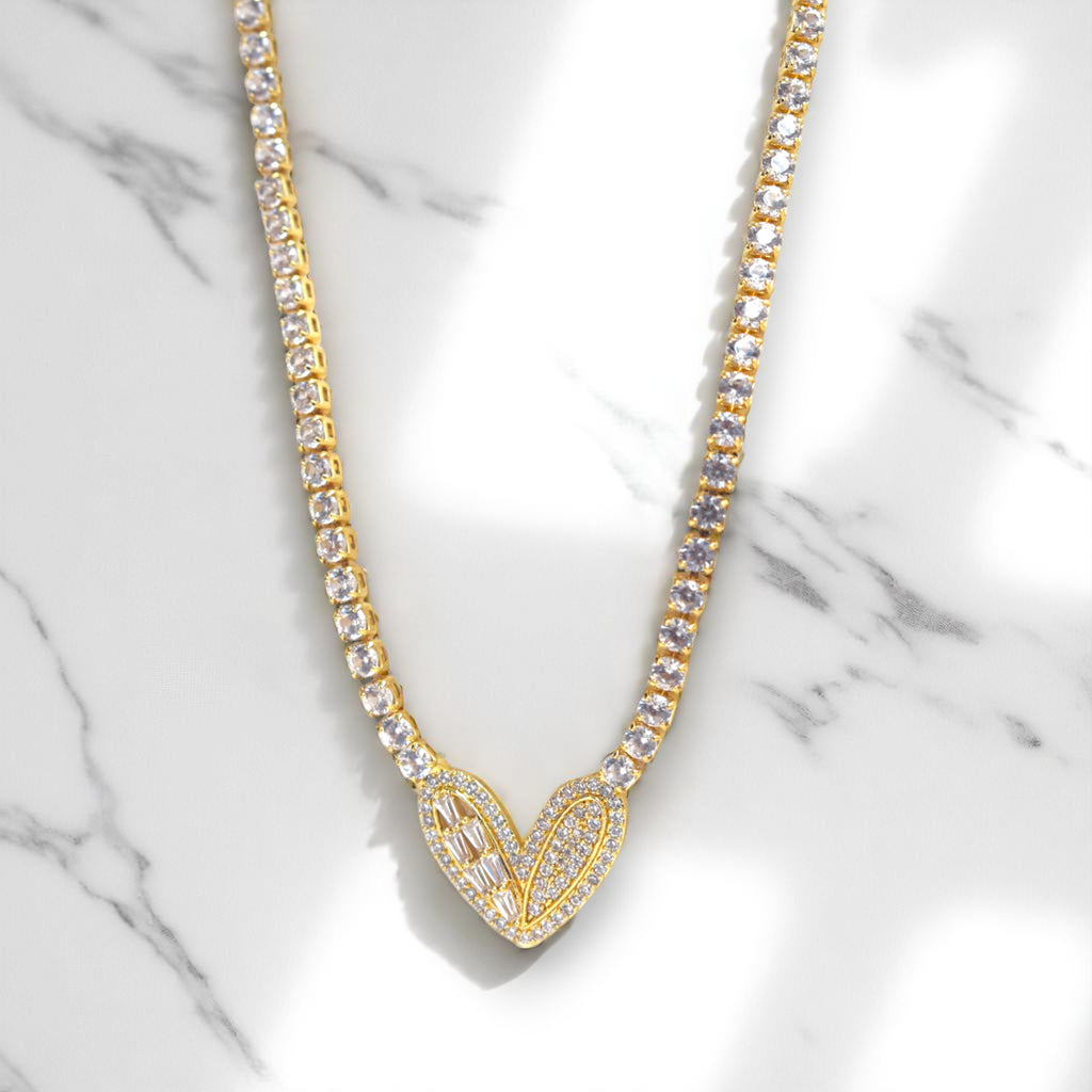 Gold necklace with clear stones on a marble background