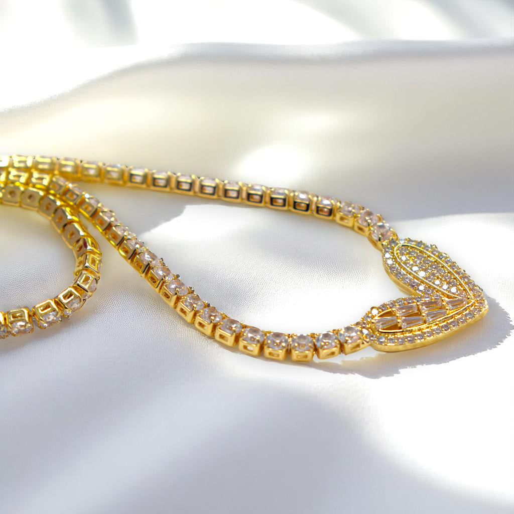 Gold necklace with clear stones on a white fabric background