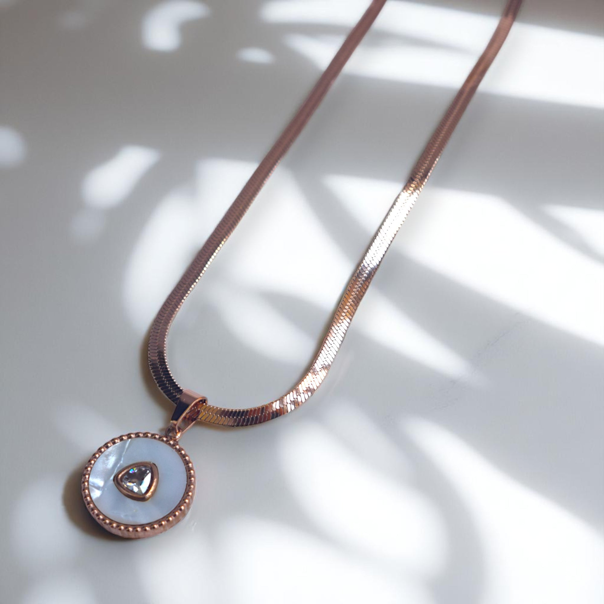 Necklace with a round pendant on a light background