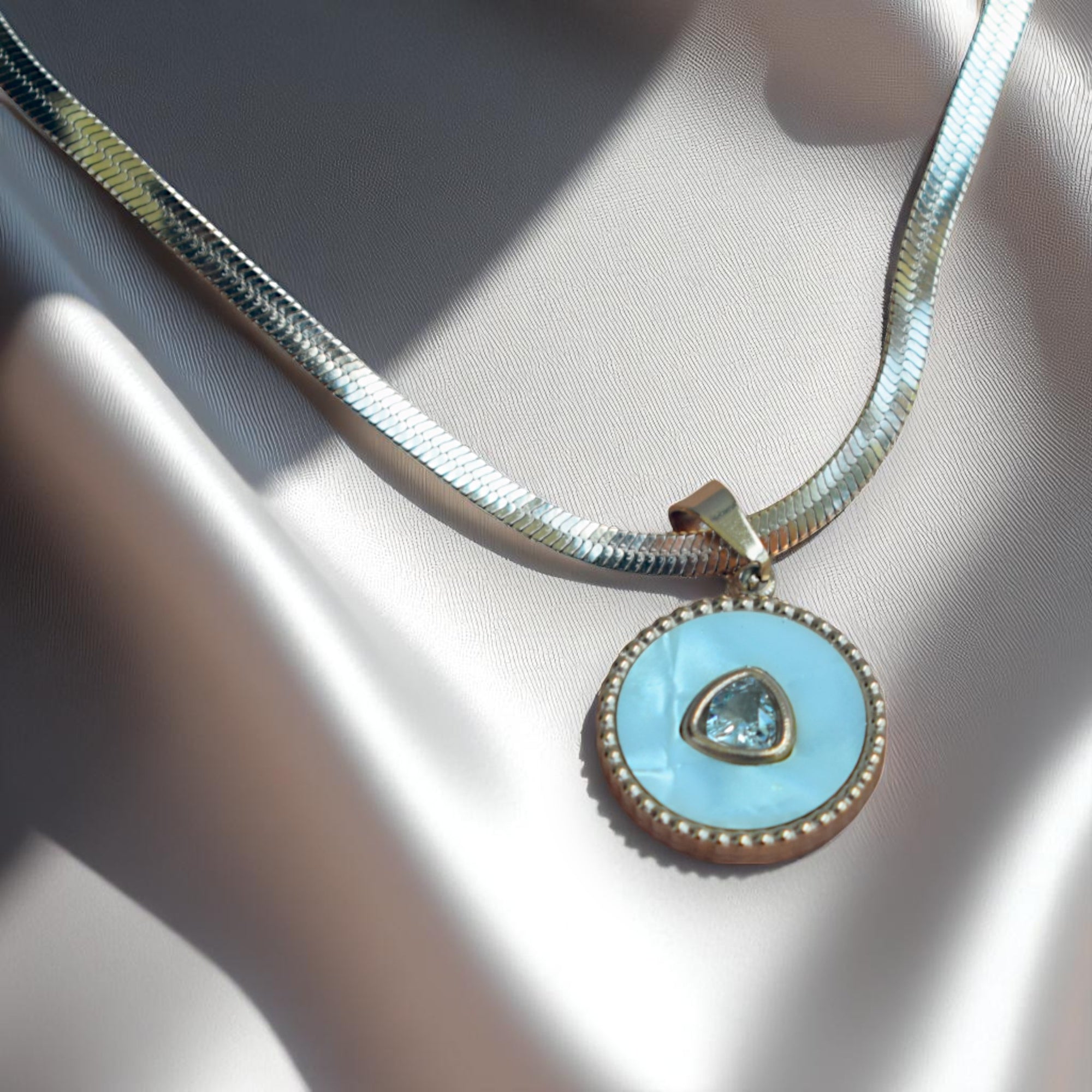 Necklace with a blue pendant on a neutral background