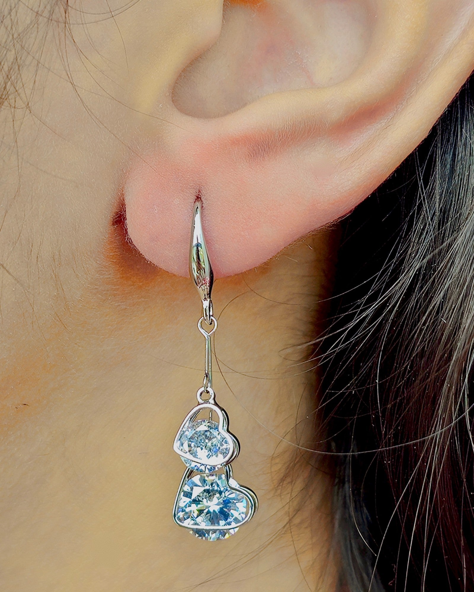 side view of a girl wearing kansobi silver love drop earrings with zirconia diamonds