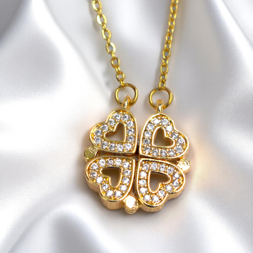 Gold necklace with a heart-shaped pendant on a white satin background