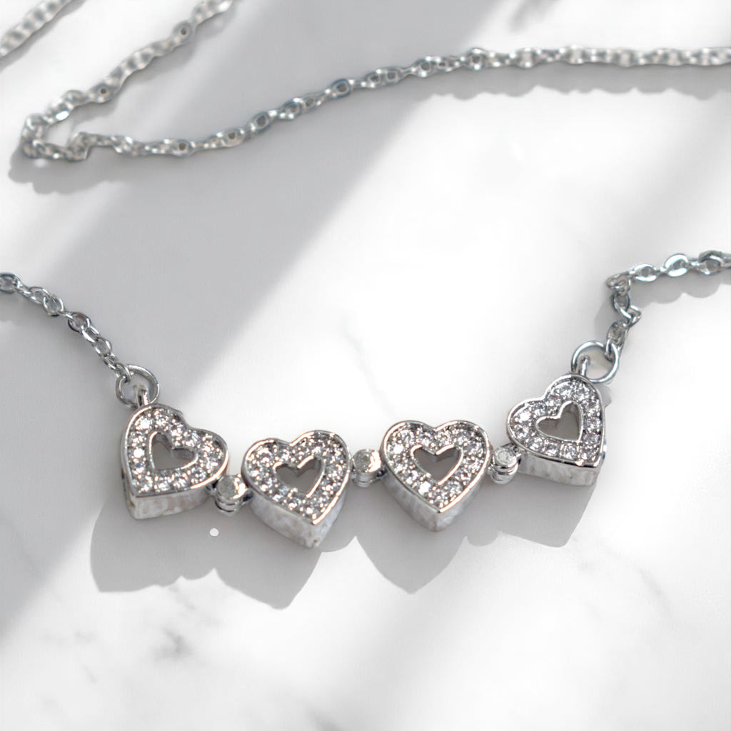 Silver necklace with heart-shaped pendants on a white background