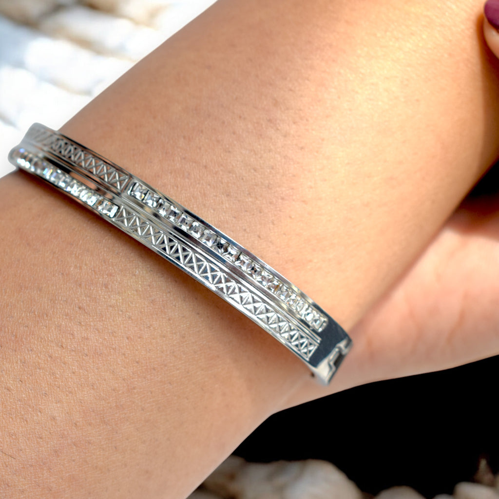 close up of a diamond studded silver bangle worn on the wrist 