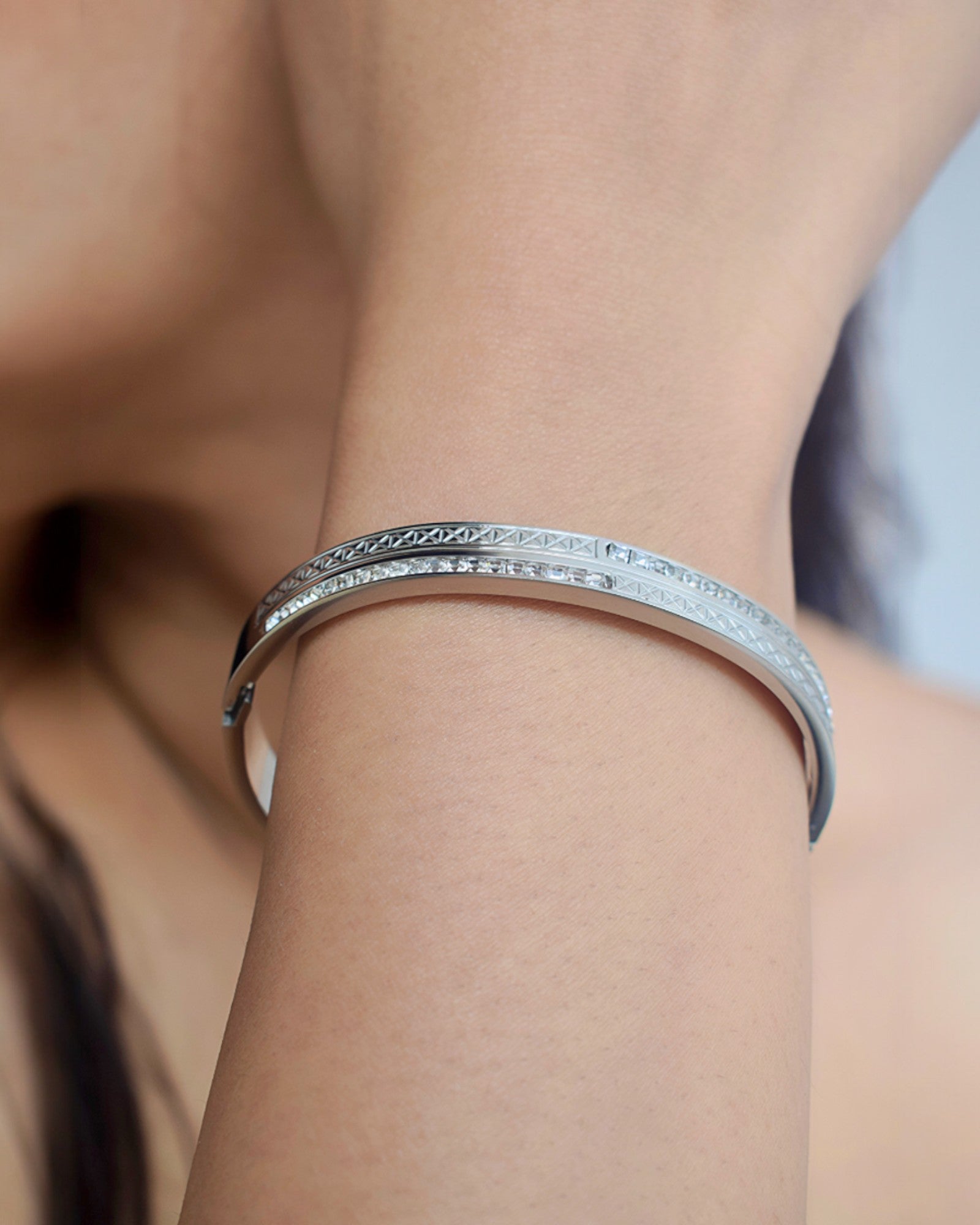 close up of a diamond studded silver bangle worn on the wrist by a girl