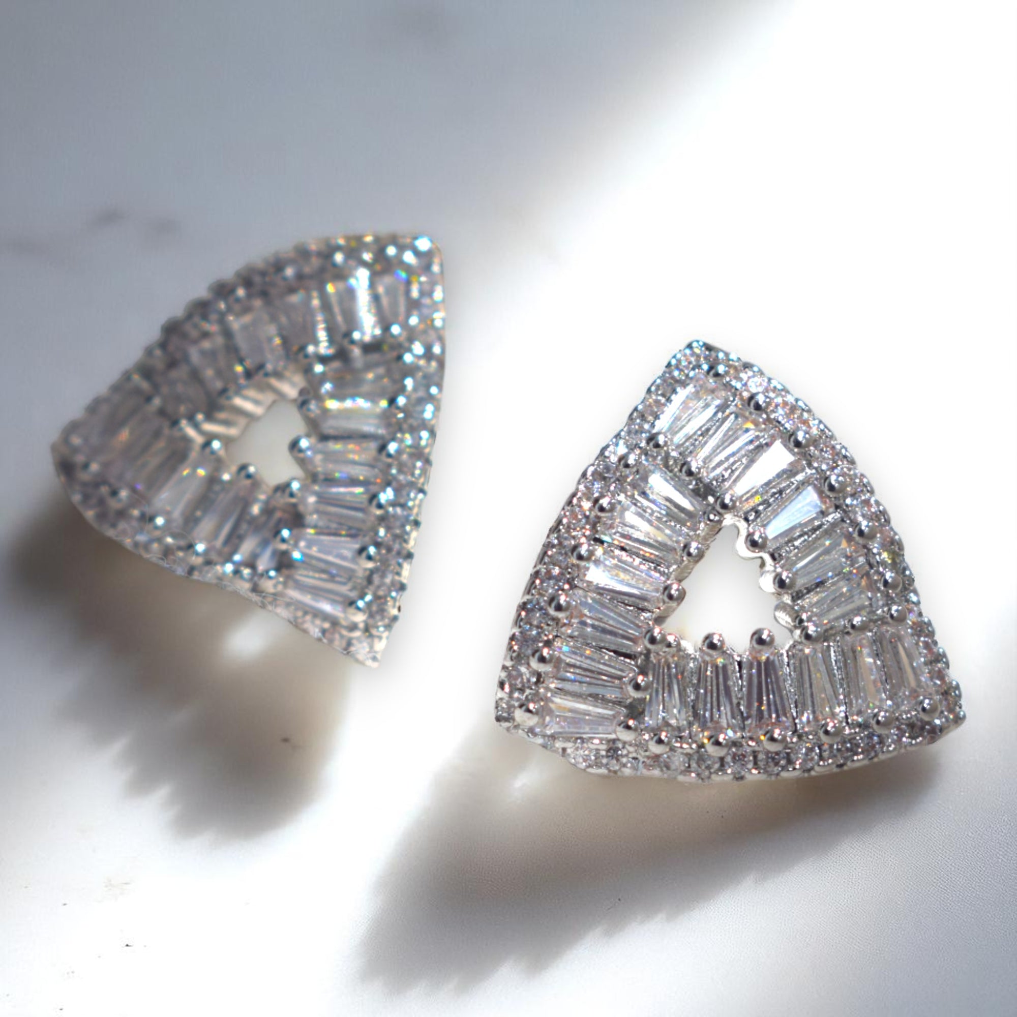 Triangular diamond earrings on a light background